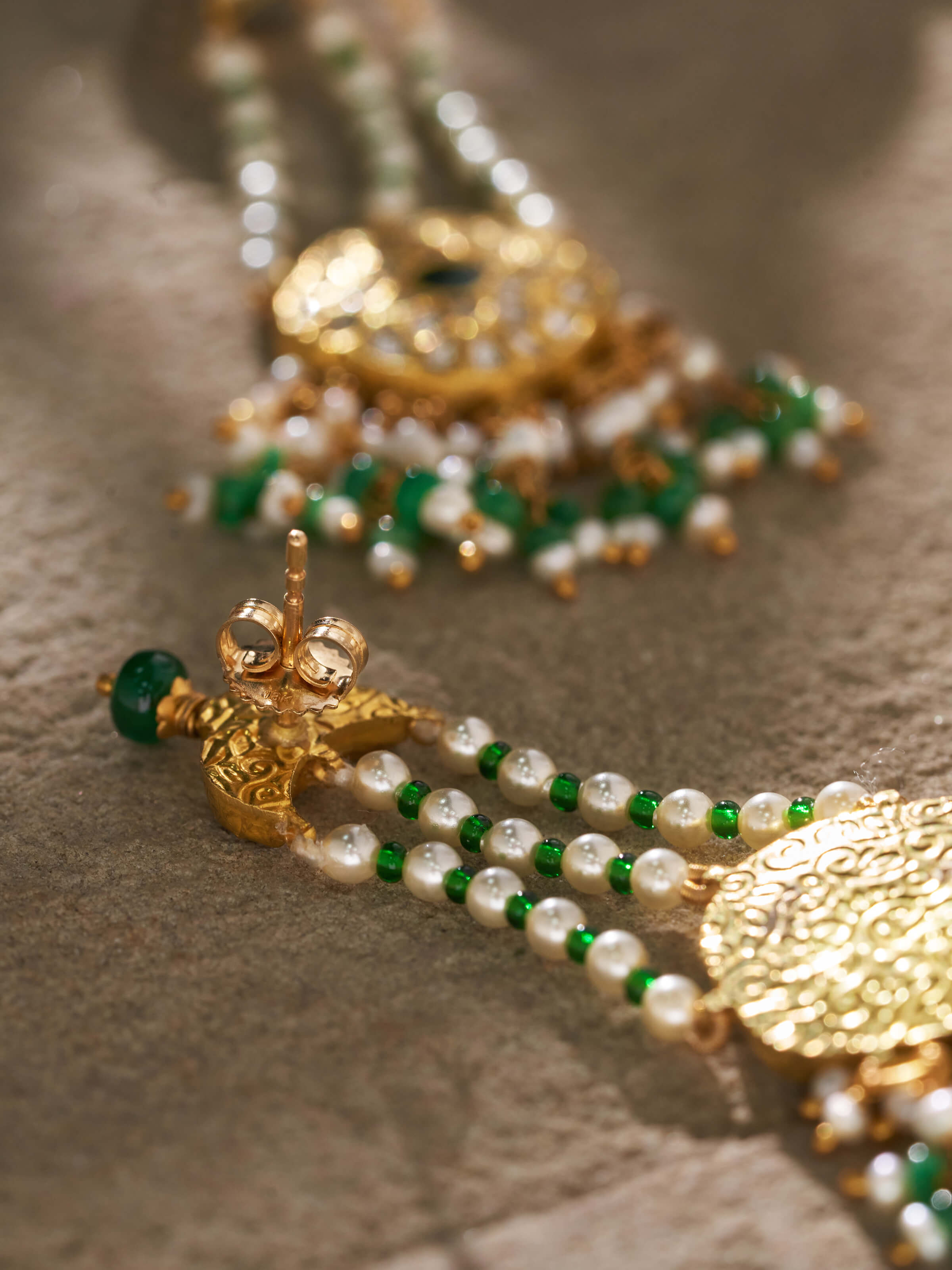 Angled shot displaying the earring’s texture and traditional drop style