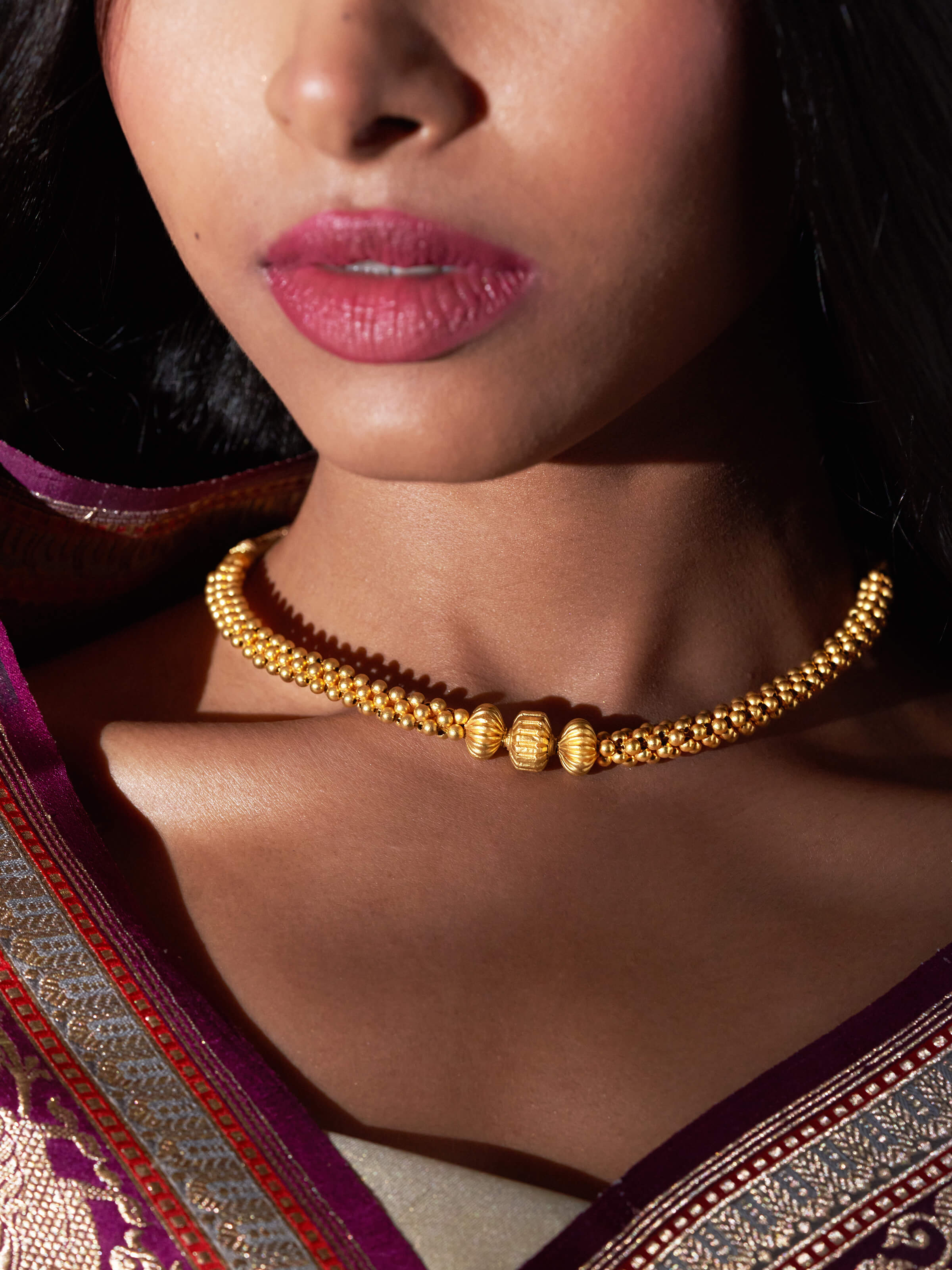 Lifestyle image of Thushi 22 Karat gold necklace highlighting the rich gold sheen and craftsmanship.
