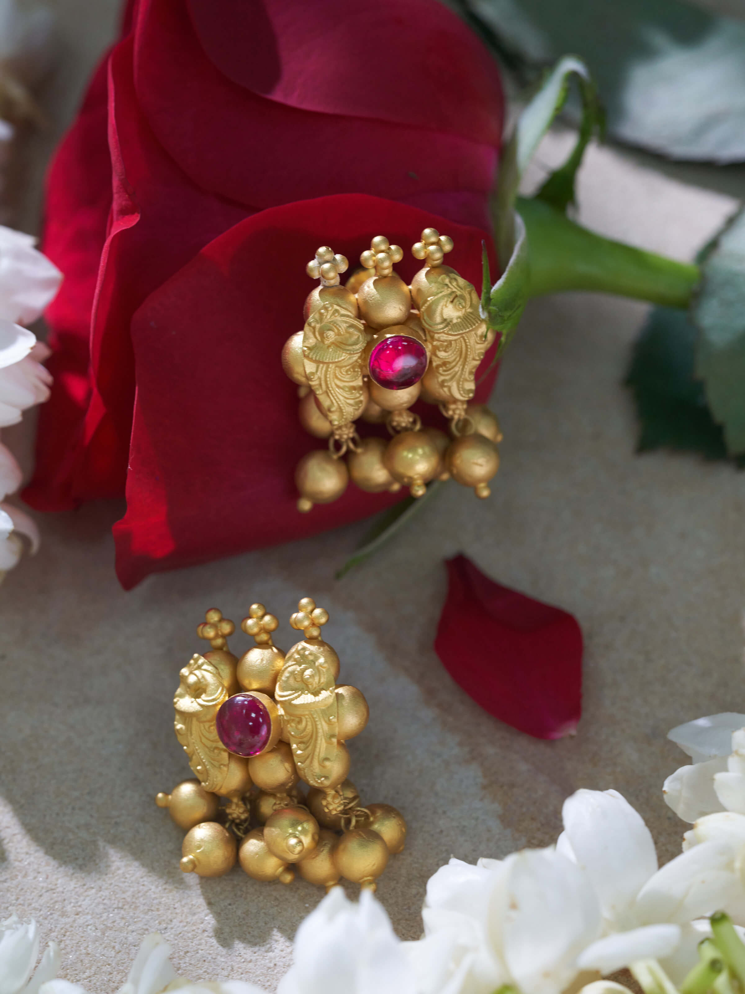 Side view of Thushi 22 karat gold drop earrings highlighting their elegant design