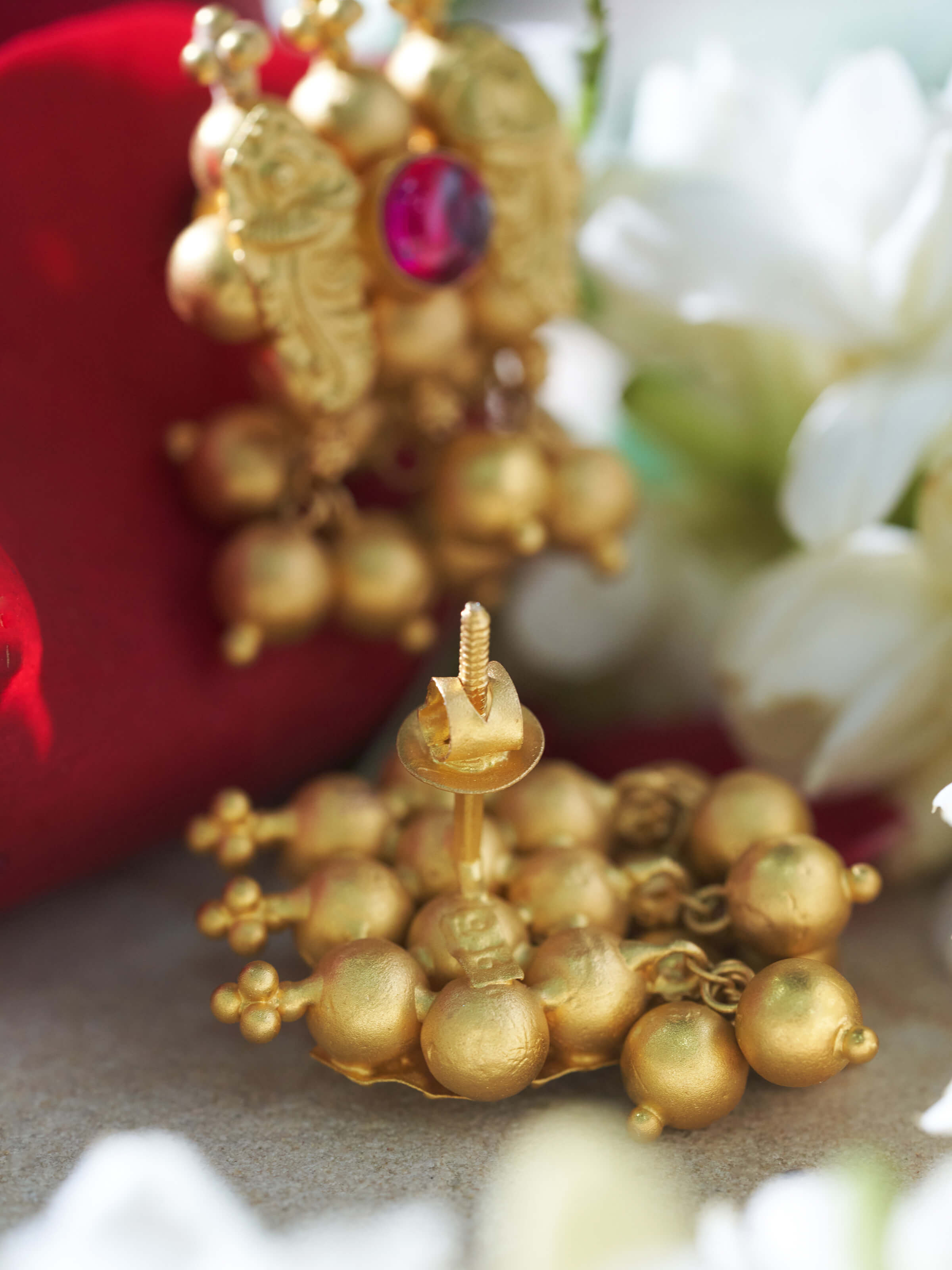 Detailed front view of Thushi 22 karat gold drop earrings highlighting ornate goldwork