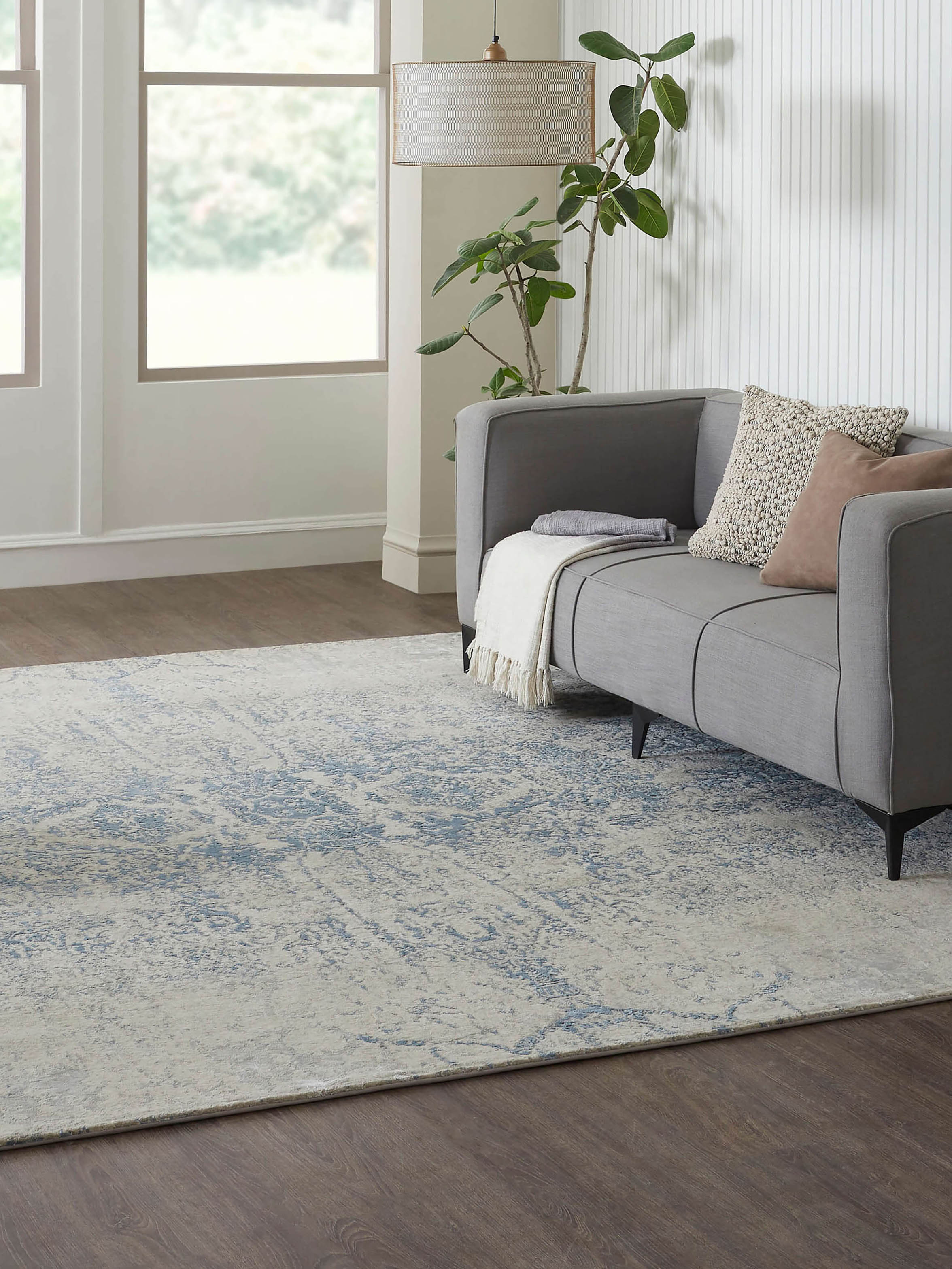 Lifestyle image of Bhadohi hand-knotted rug in distressed blue tones, combining modern and transitional design aesthetics in wool and viscose blend.