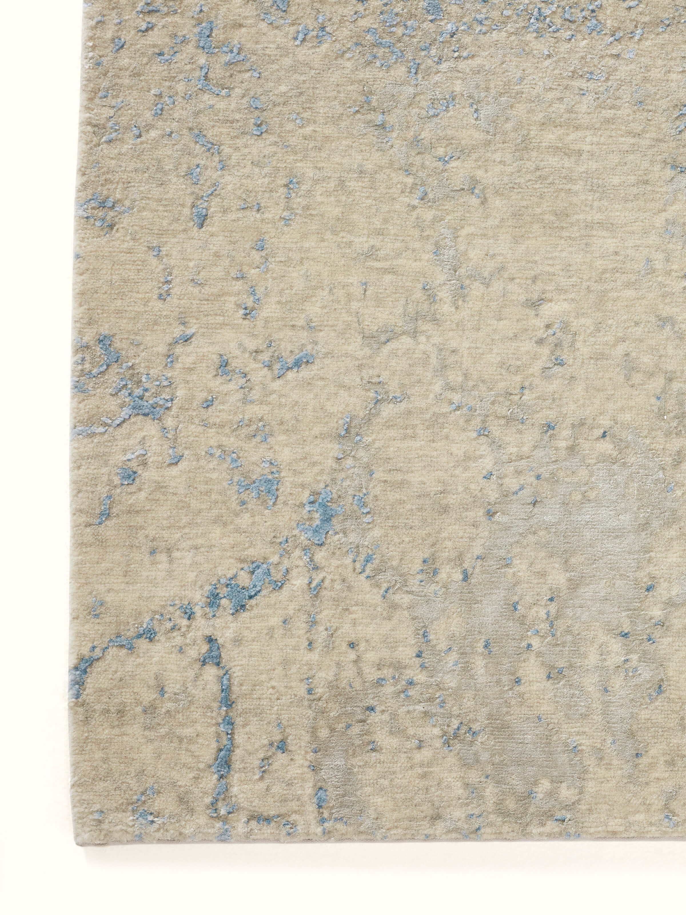 Side view of Modern Distressed Transitional Blue Bhadohi Wool & Viscose Hand-Knotted Rug, displaying the thickness and texture of the rug.