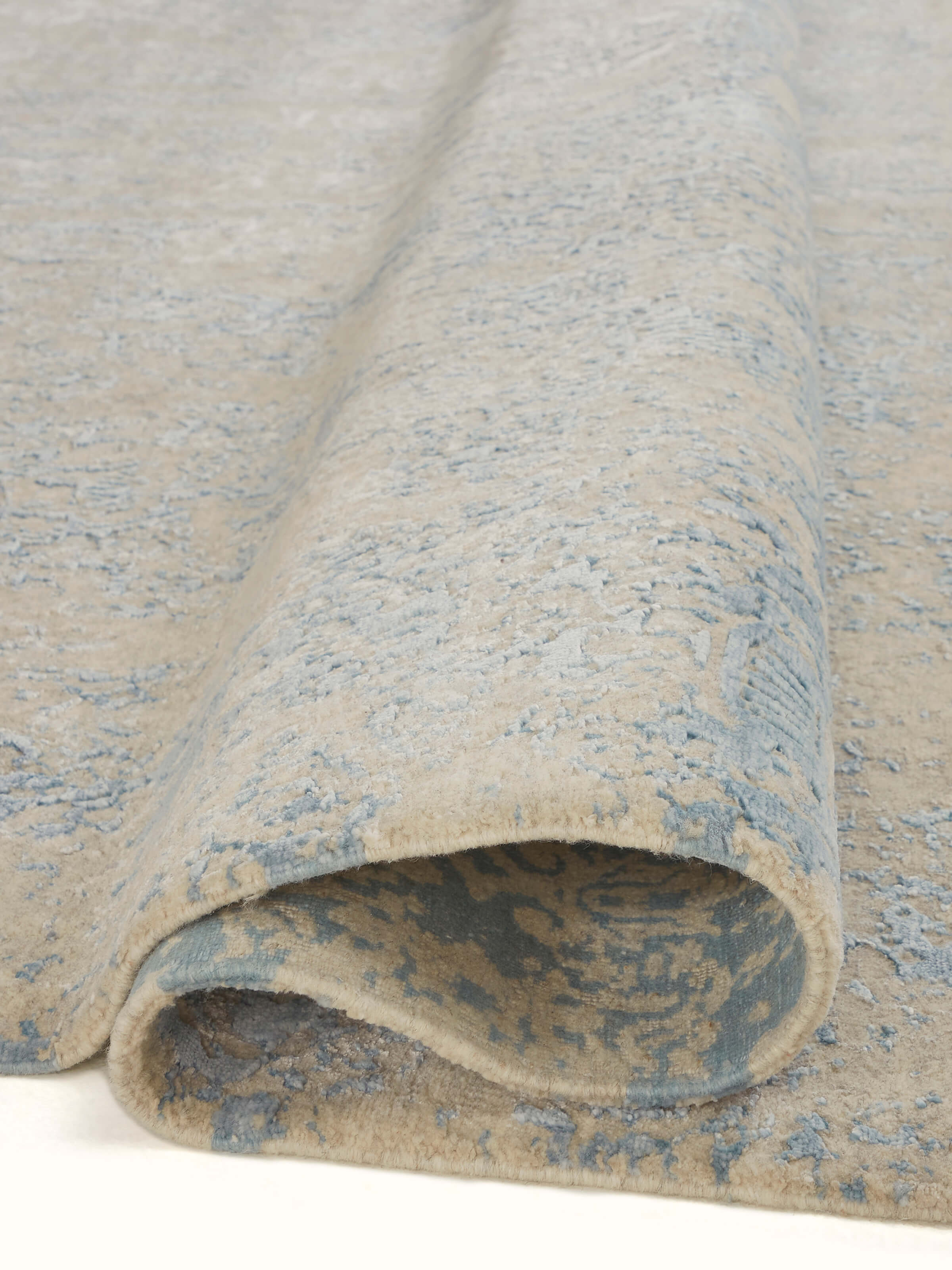 Detailed view of Modern Distressed Transitional Blue Bhadohi Wool & Viscose Hand-Knotted Rug, emphasizing the intricate weaving and distressed design.