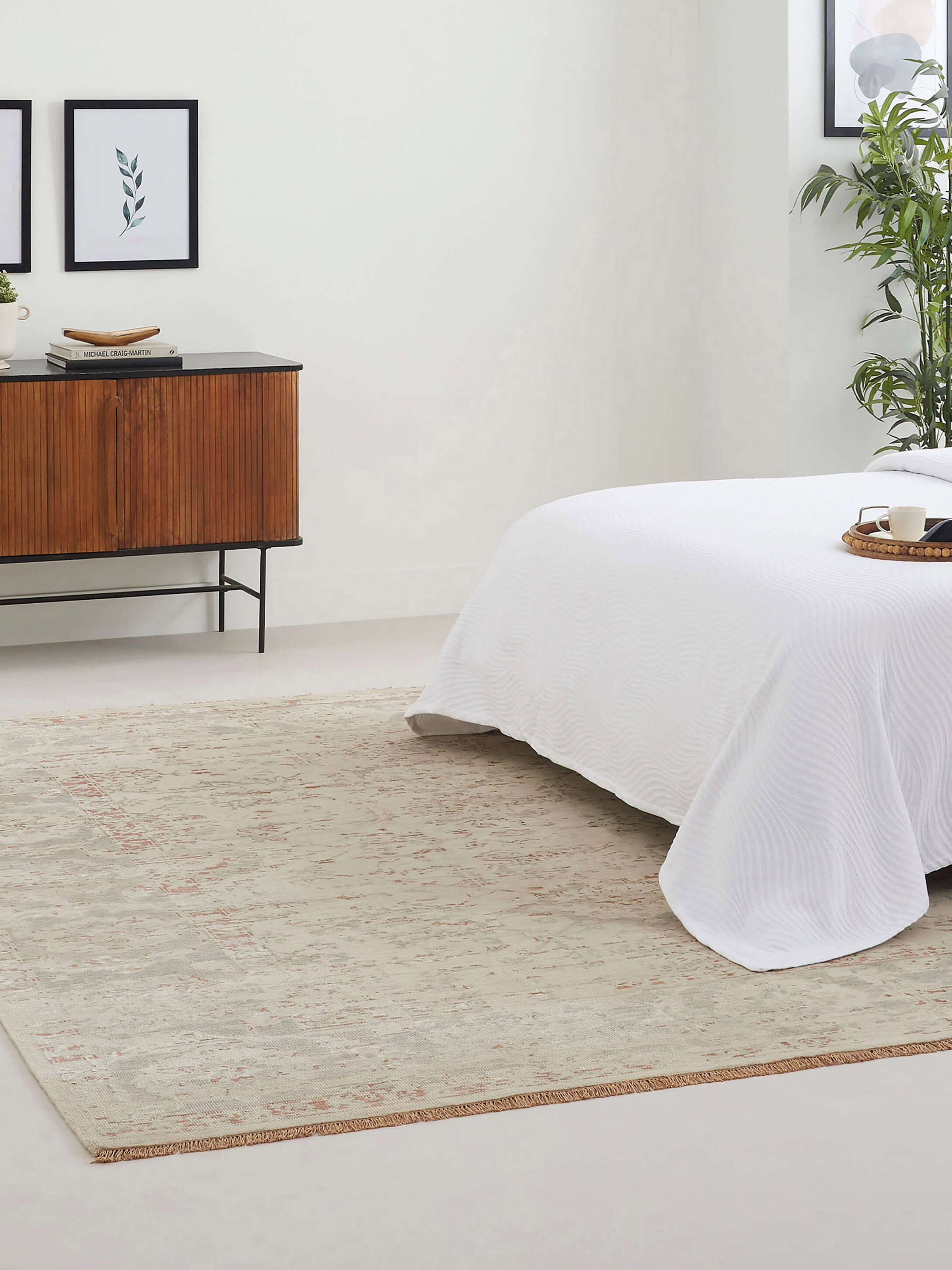 Room view of hand-knotted beige and grey Bhadohi rug with distressed transitional pattern in wool and silk blend.