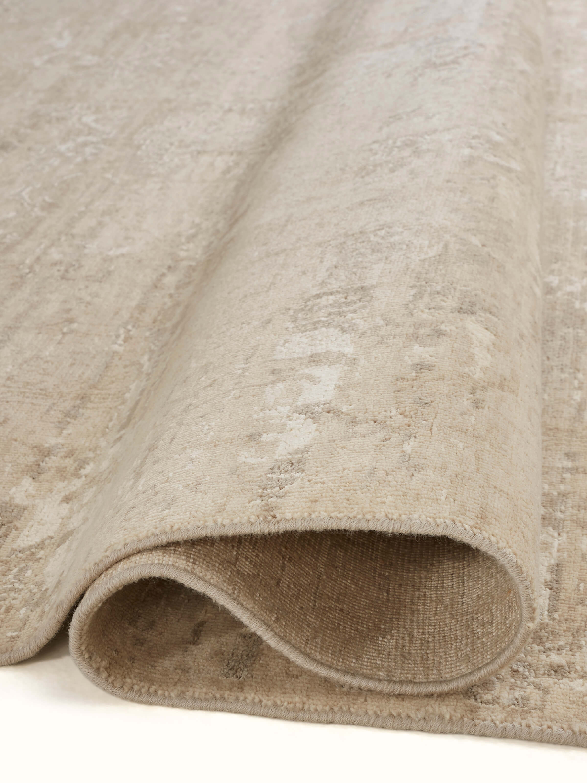 Side view of the Distressed Transitional Beige Brown Bhadohi Wool & Silk Hand-Knotted Rug, showing the rug’s depth and design layers.