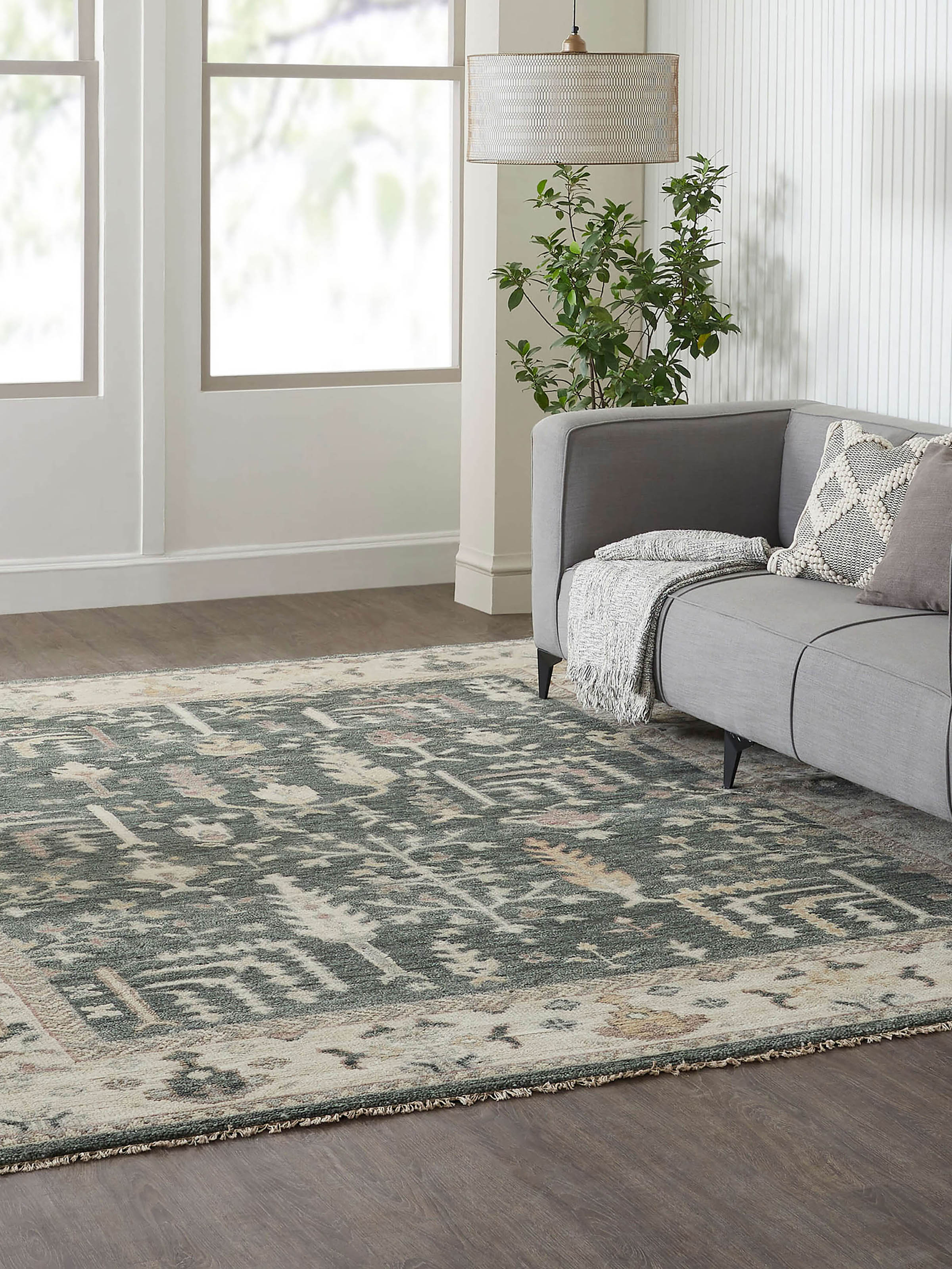 Lifestyle shot: Oushak green wool rug styled in traditional living space with rich heritage detailing.