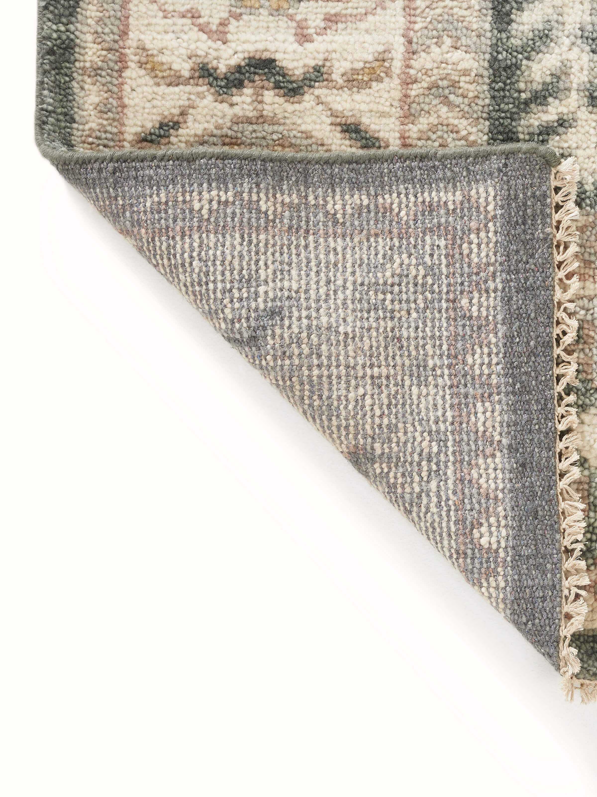 Oushak traditional grey Bhadohi wool hand-knotted rug kharad with emphasis on the rug’s color and pattern variations.