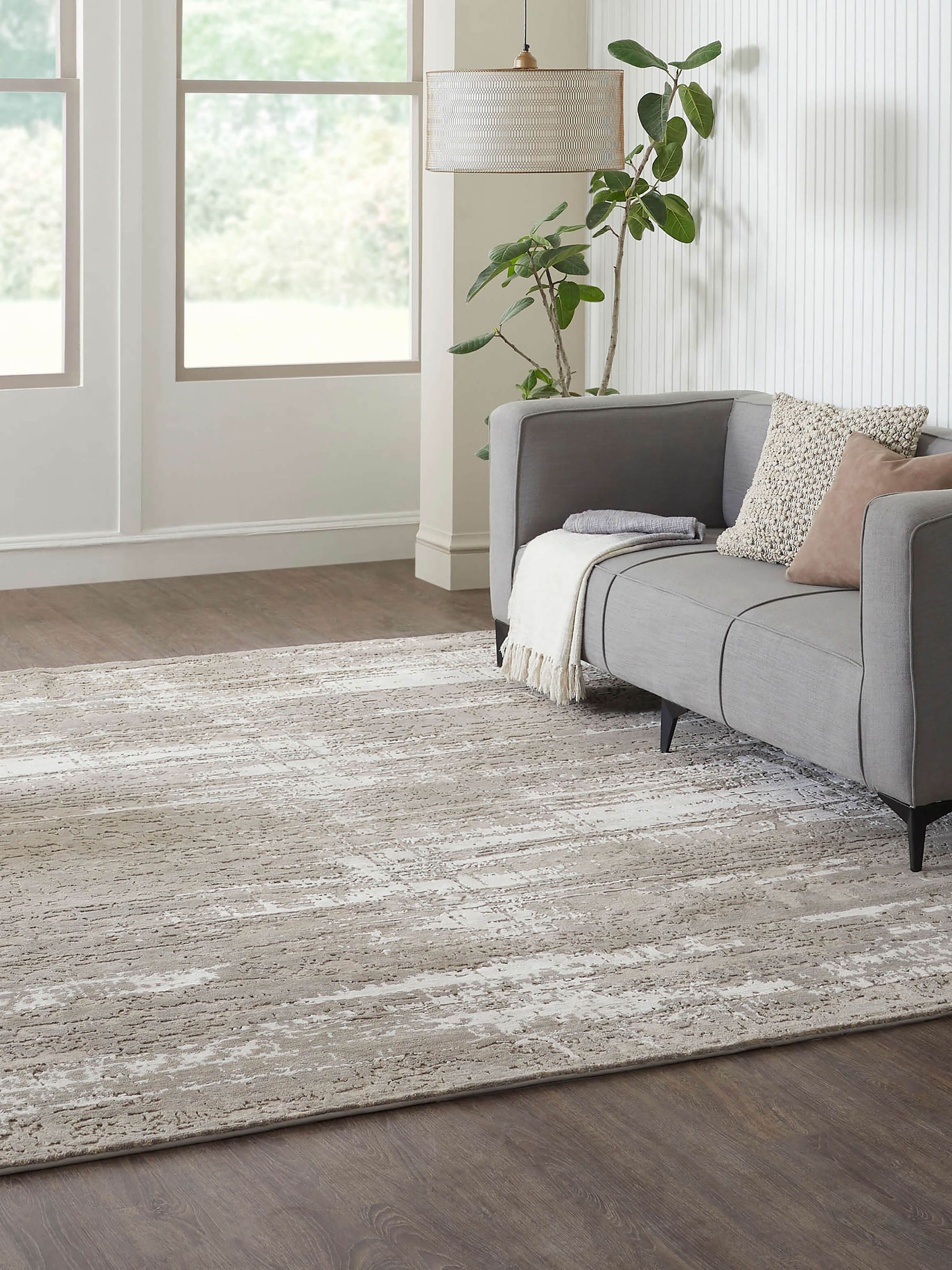 Modern abstract grey silver Bhadohi wool and viscose hand-knotted rug in living room setting – Swadesh