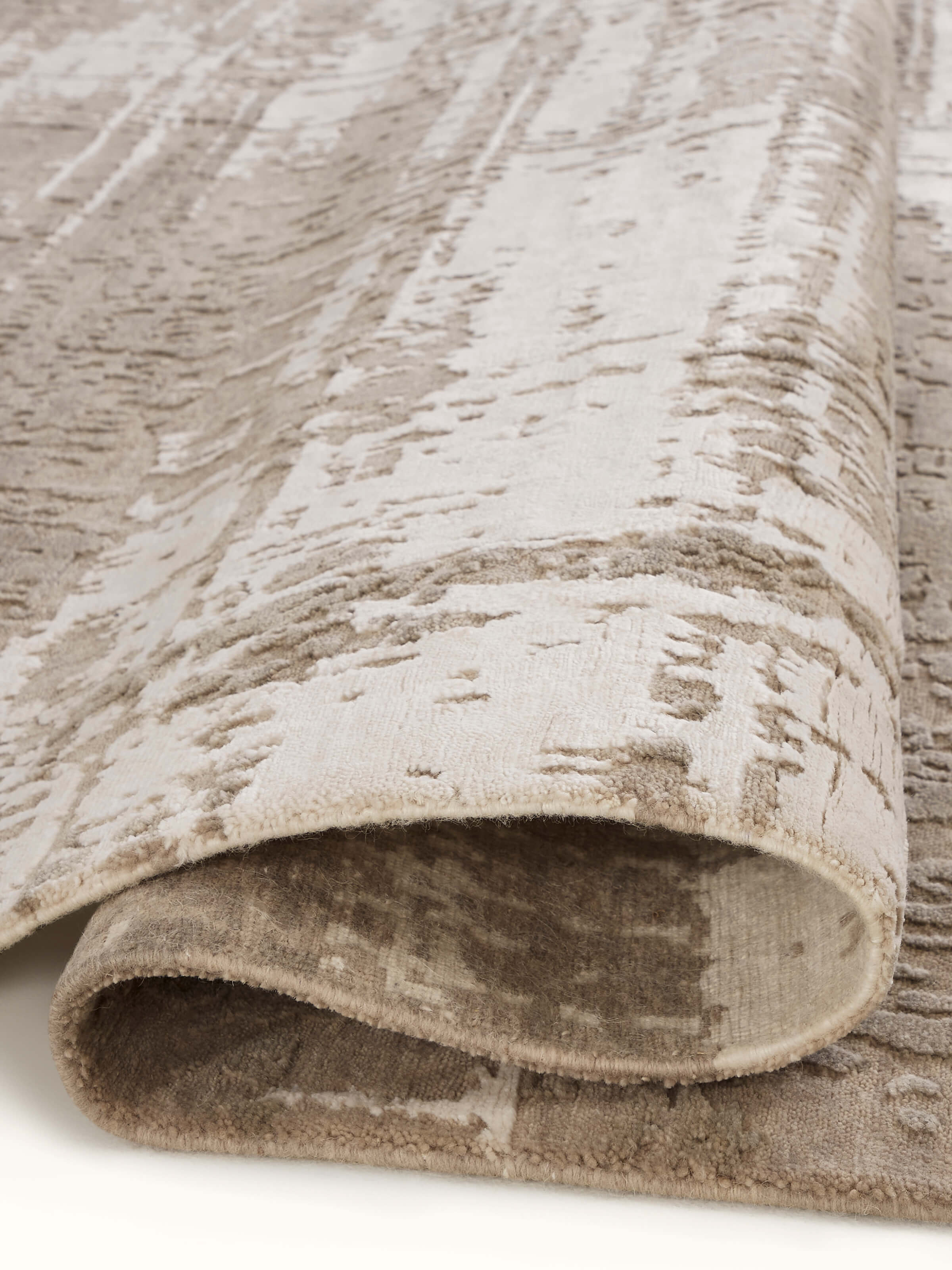 Full view of Modern distress abstract grey silver Bhadohi wool & viscose hand-knotted rug laid out in a modern living space