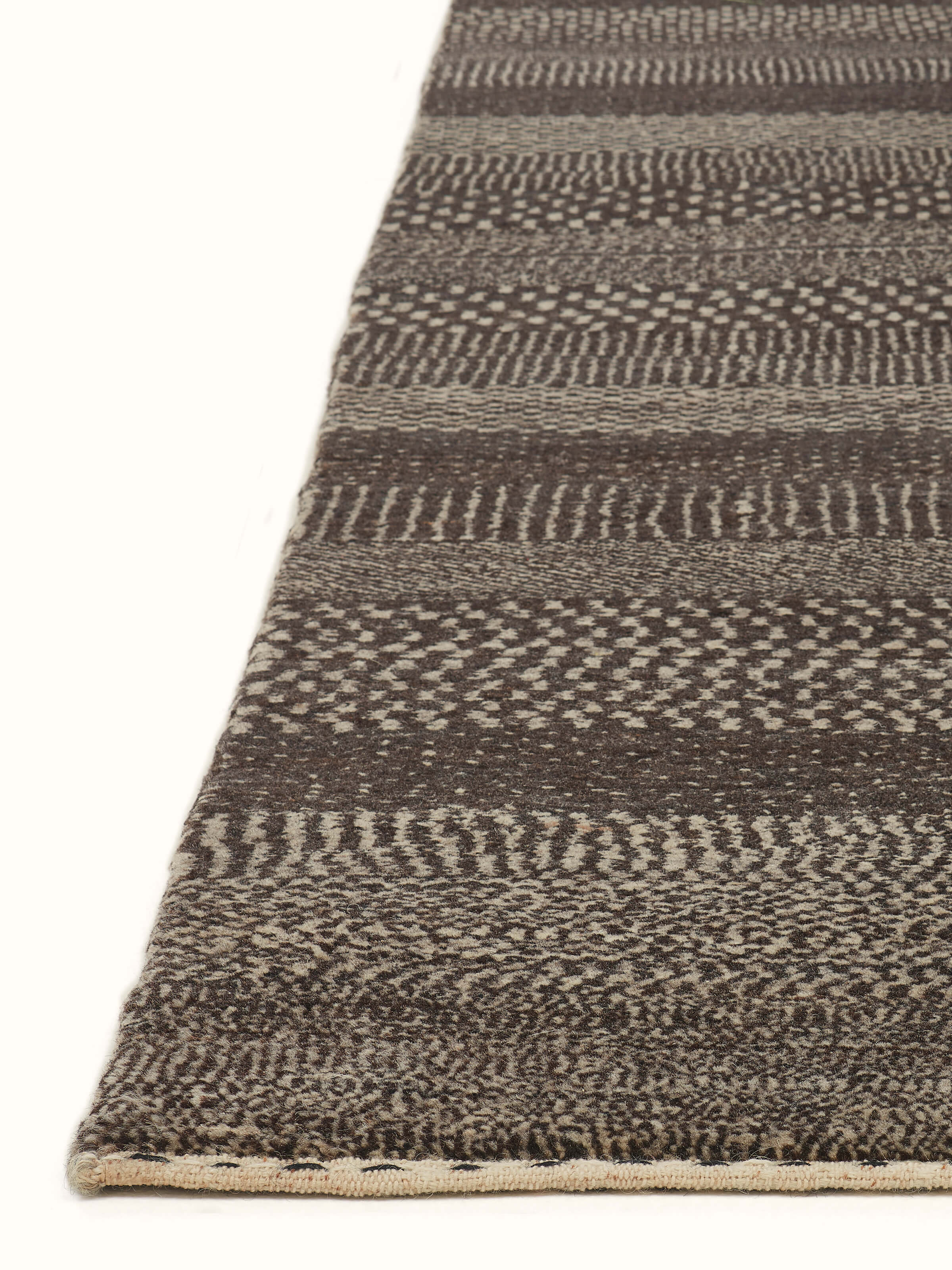 Angled view of Traditional Gabbeh Grey Charcoal Bhadohi Wool Hand-Knotted Rug displaying the depth and quality of the woolen material.