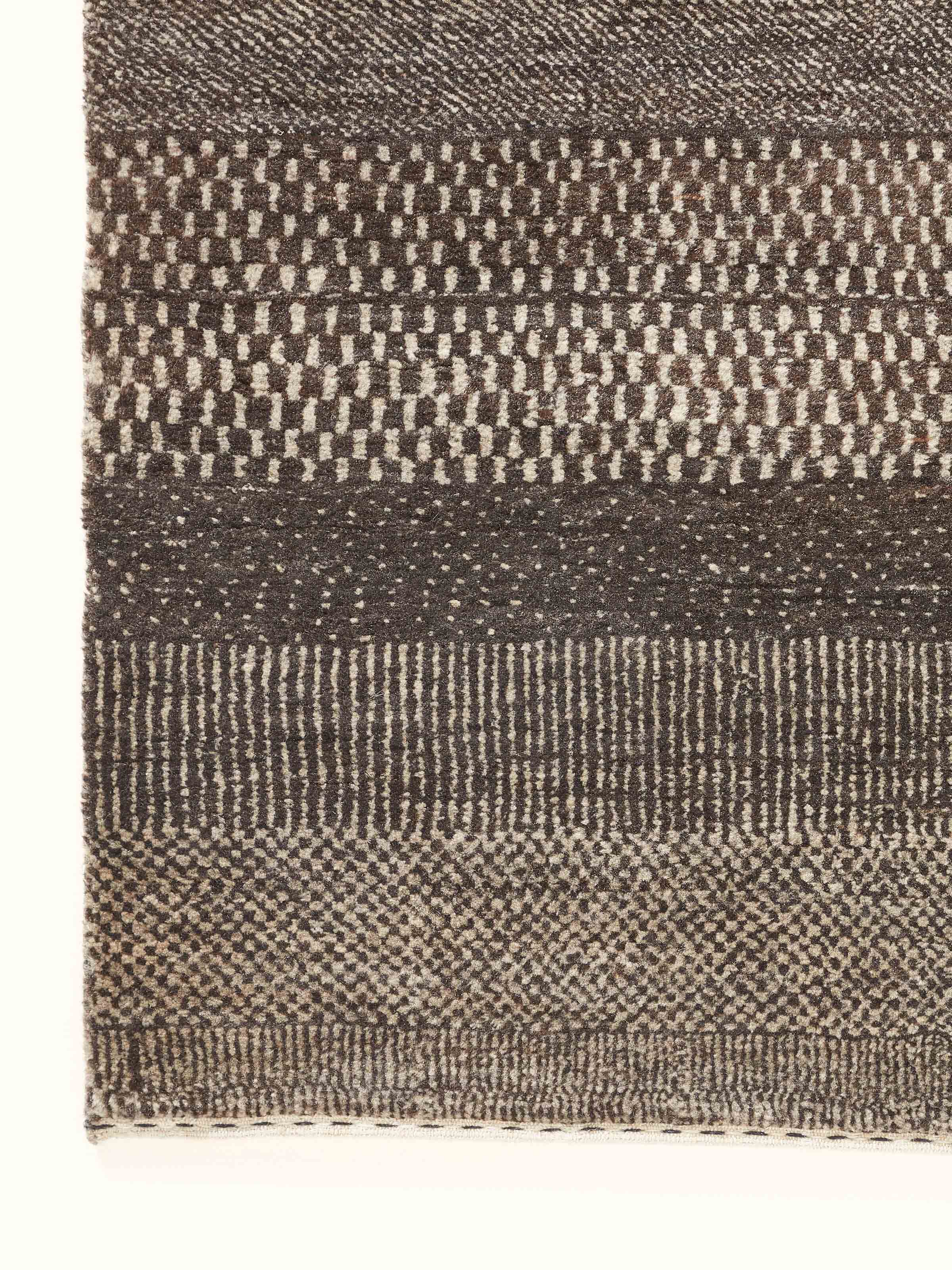 Side view of Traditional Gabbeh Grey Charcoal Bhadohi Wool Hand-Knotted Rug showing the thickness and edge of the rug.