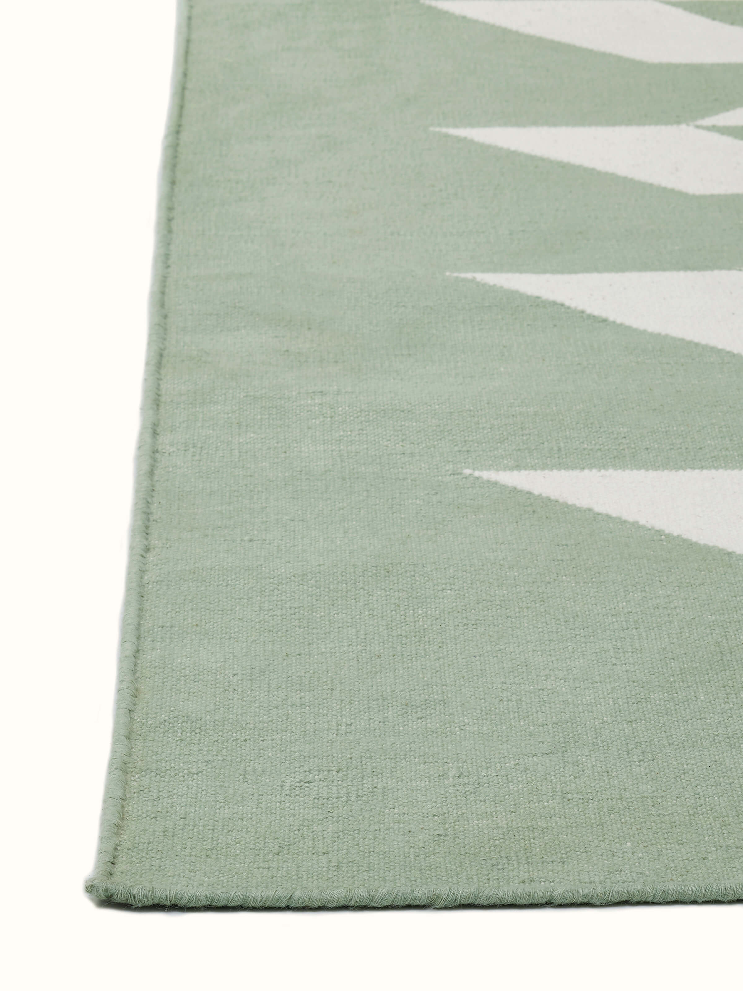 Close-up of Modern geo chevron light green ivory lawan cotton panja dhurrie kharad focusing on the geometric pattern and fabric quality.