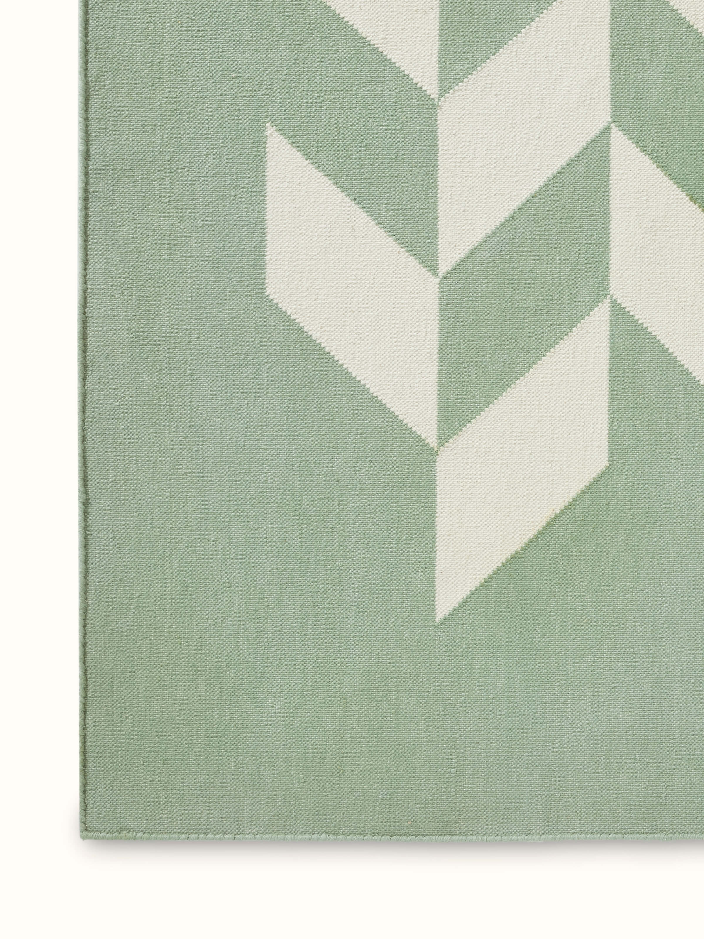 Detailed view of Modern geo chevron light green ivory lawan cotton panja dhurrie kharad showcasing the chevron pattern and colors.