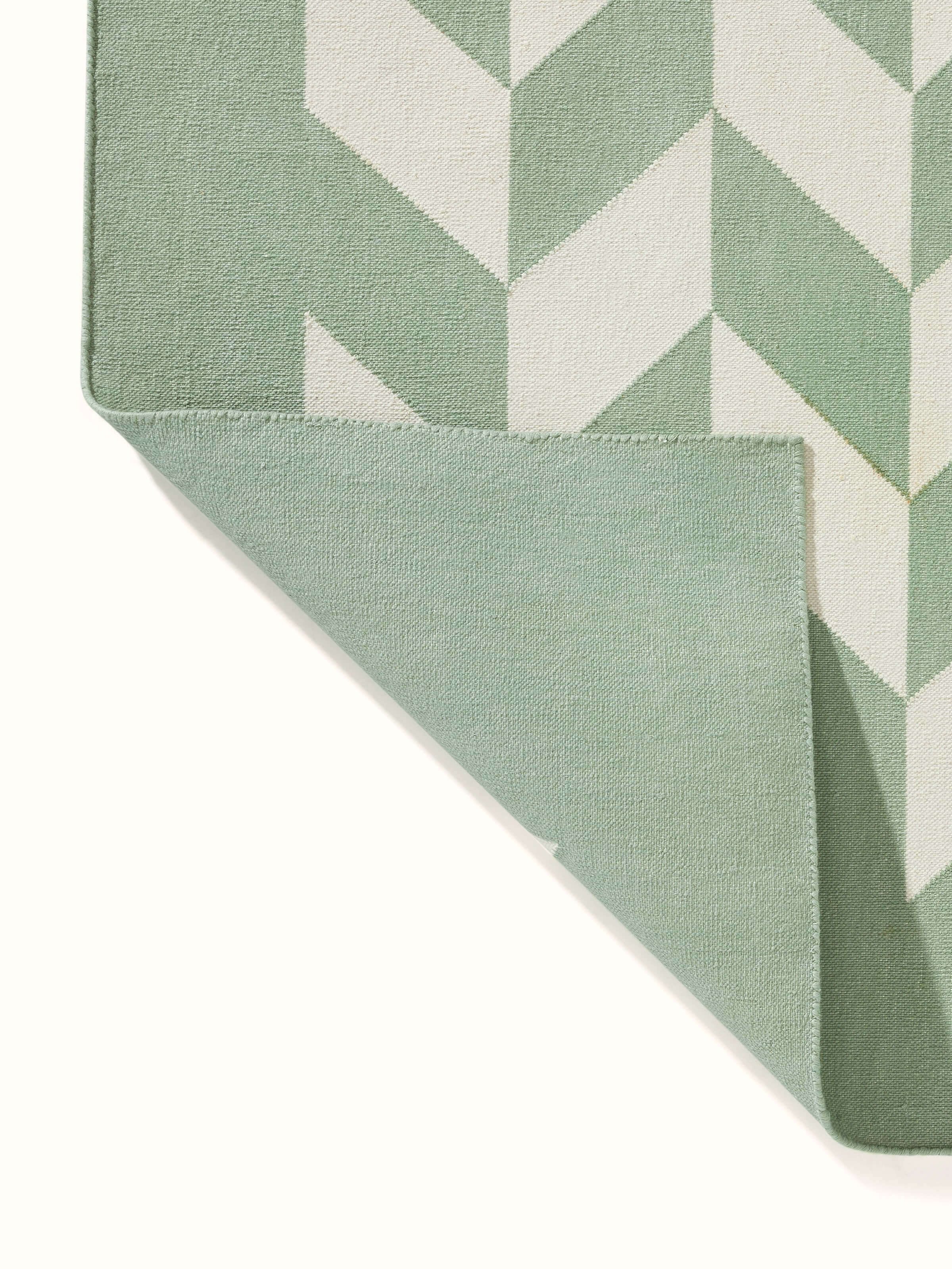 Modern geo chevron light green ivory lawan cotton panja dhurrie kharad featuring a close-up of the geometric design and fabric.