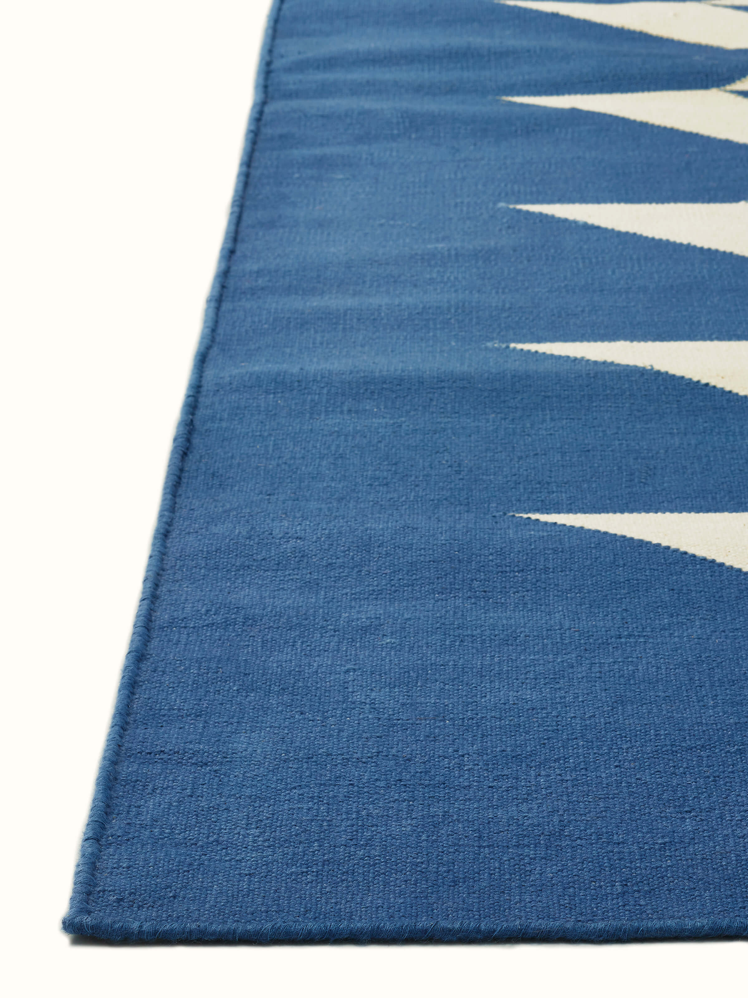 Modern geo chevron blue ivory Lawan cotton Panja dhurrie in a room setting, showcasing its design