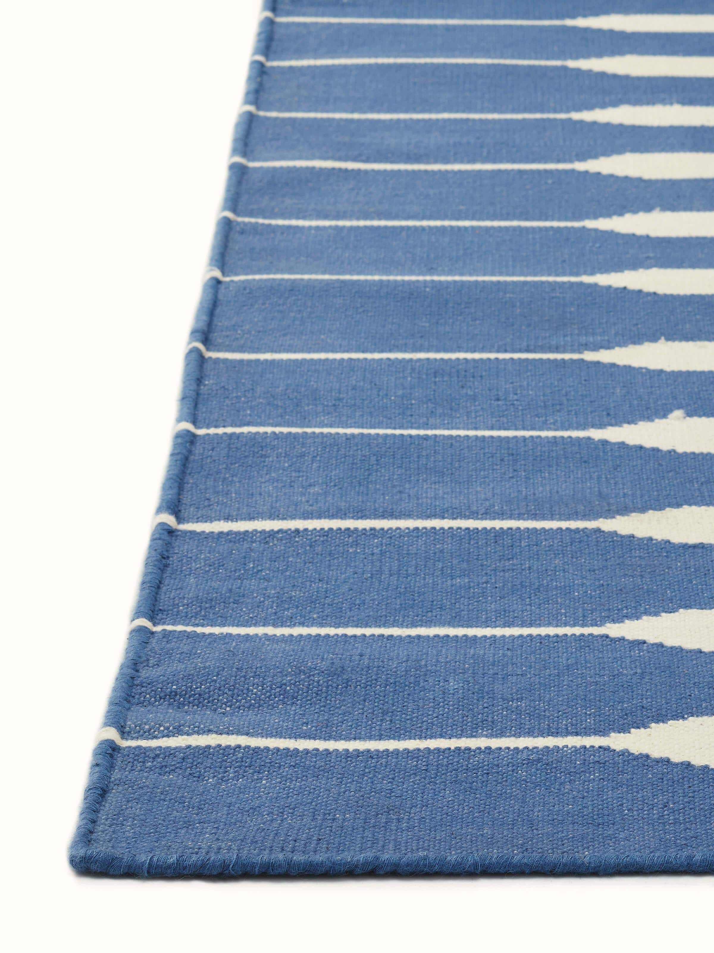 Side view of Modern geo stripe blue lawan cotton panja dhurrie displaying the geometric design and fabric texture.