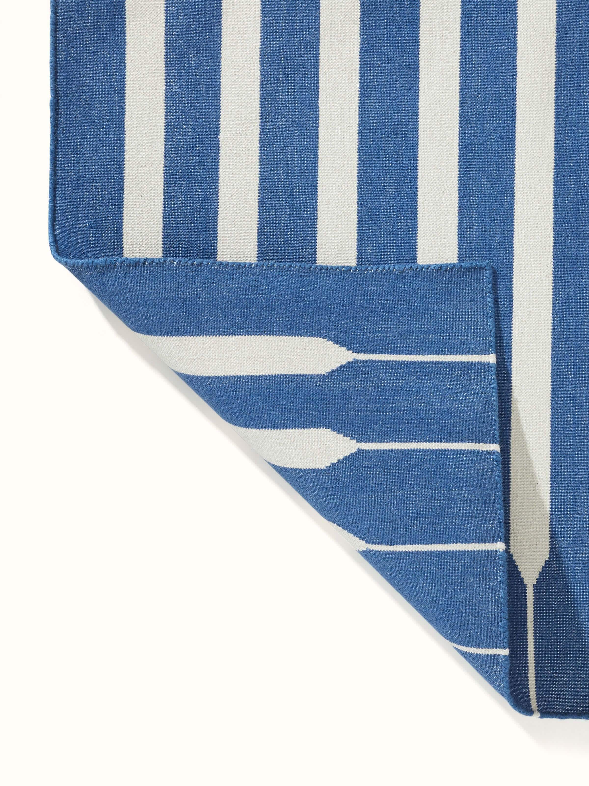 Perspective view of Modern geo stripe blue lawan cotton panja dhurrie capturing its geometric pattern and overall design.