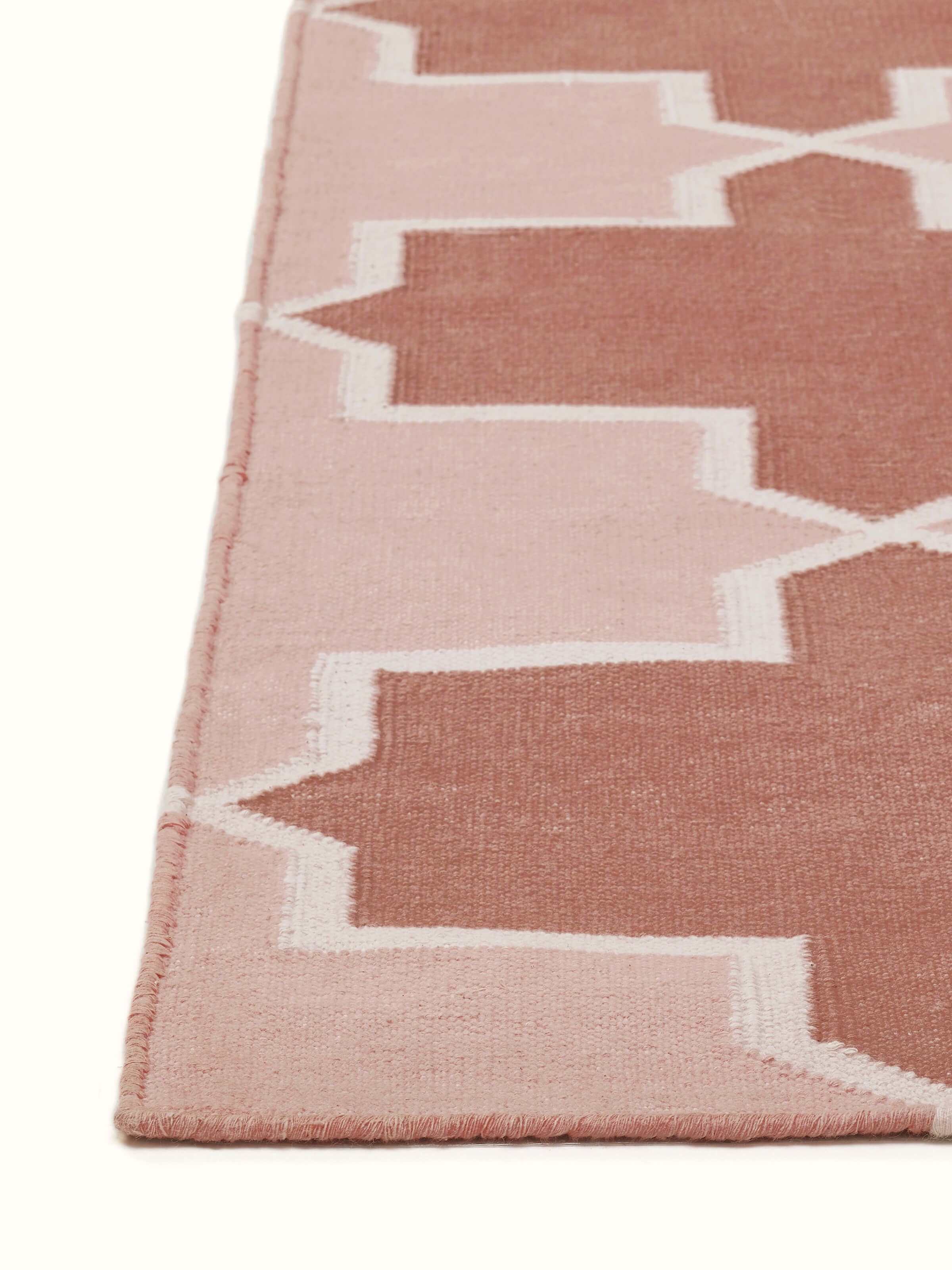 Angled view of Modern Geo Red Blush Lawan Cotton Panja Dhurrie emphasizing the detailed geometric patterns