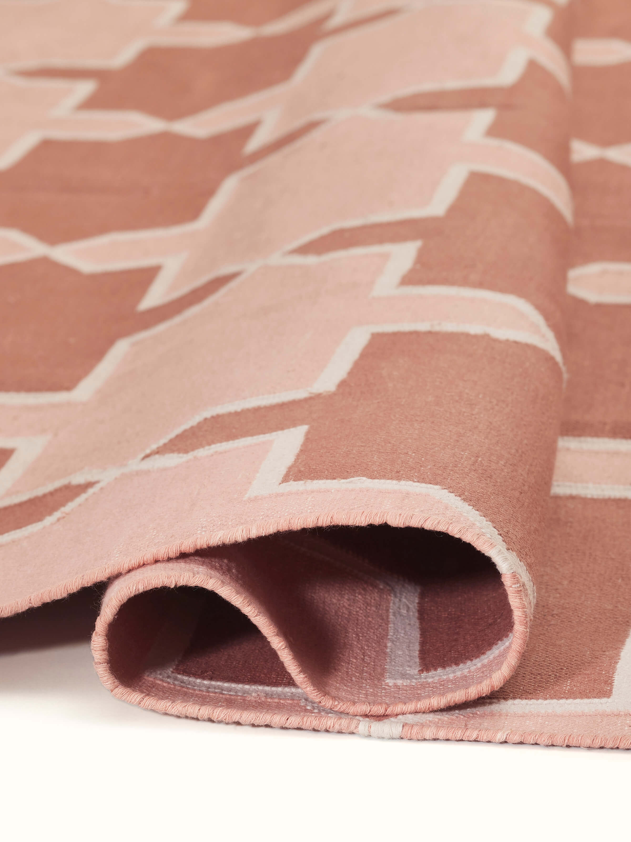 Close-up of Modern Geo Red Blush Lawan Cotton Panja Dhurrie showing the quality of the fabric and intricate design