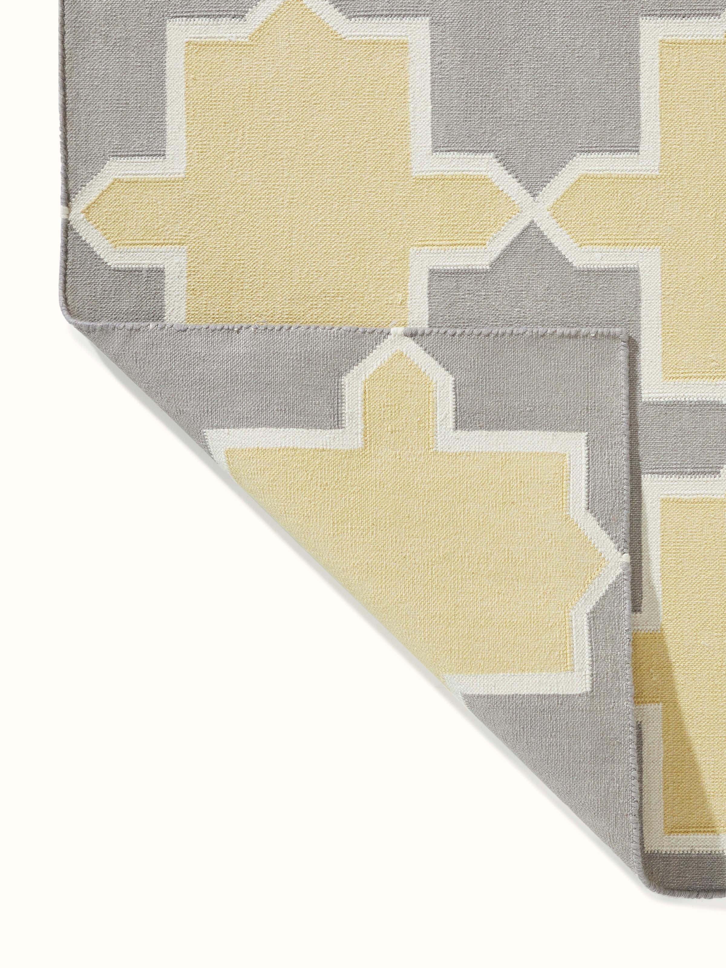 Close-up of Modern Geo grey yellow Lawan cotton panja dhurrie focusing on the geometric patterns and color details