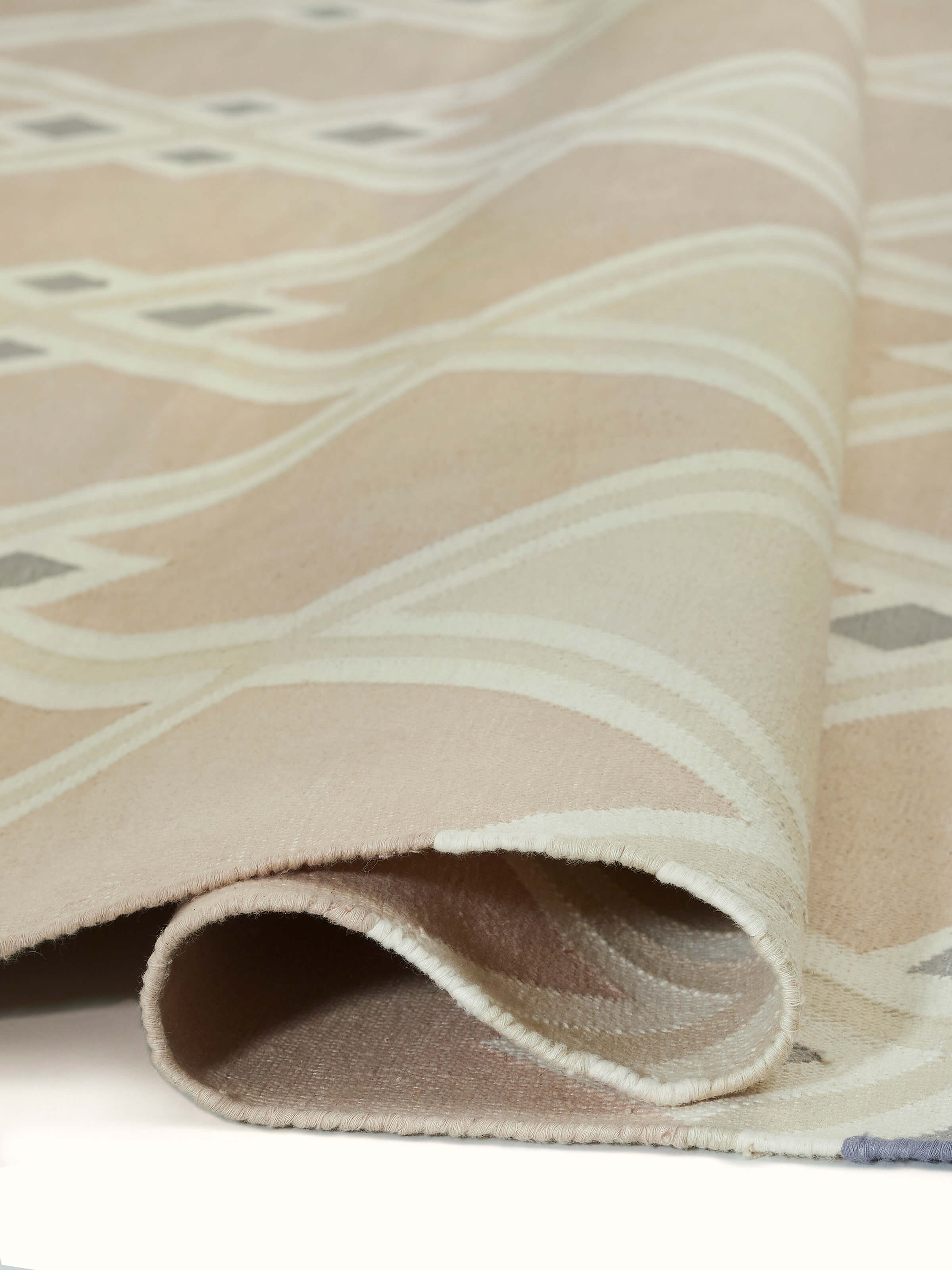 Angled shot of Modern Geo Diamond beige-grey Lawan cotton panja dhurrie, showing the texture and design from a side perspective