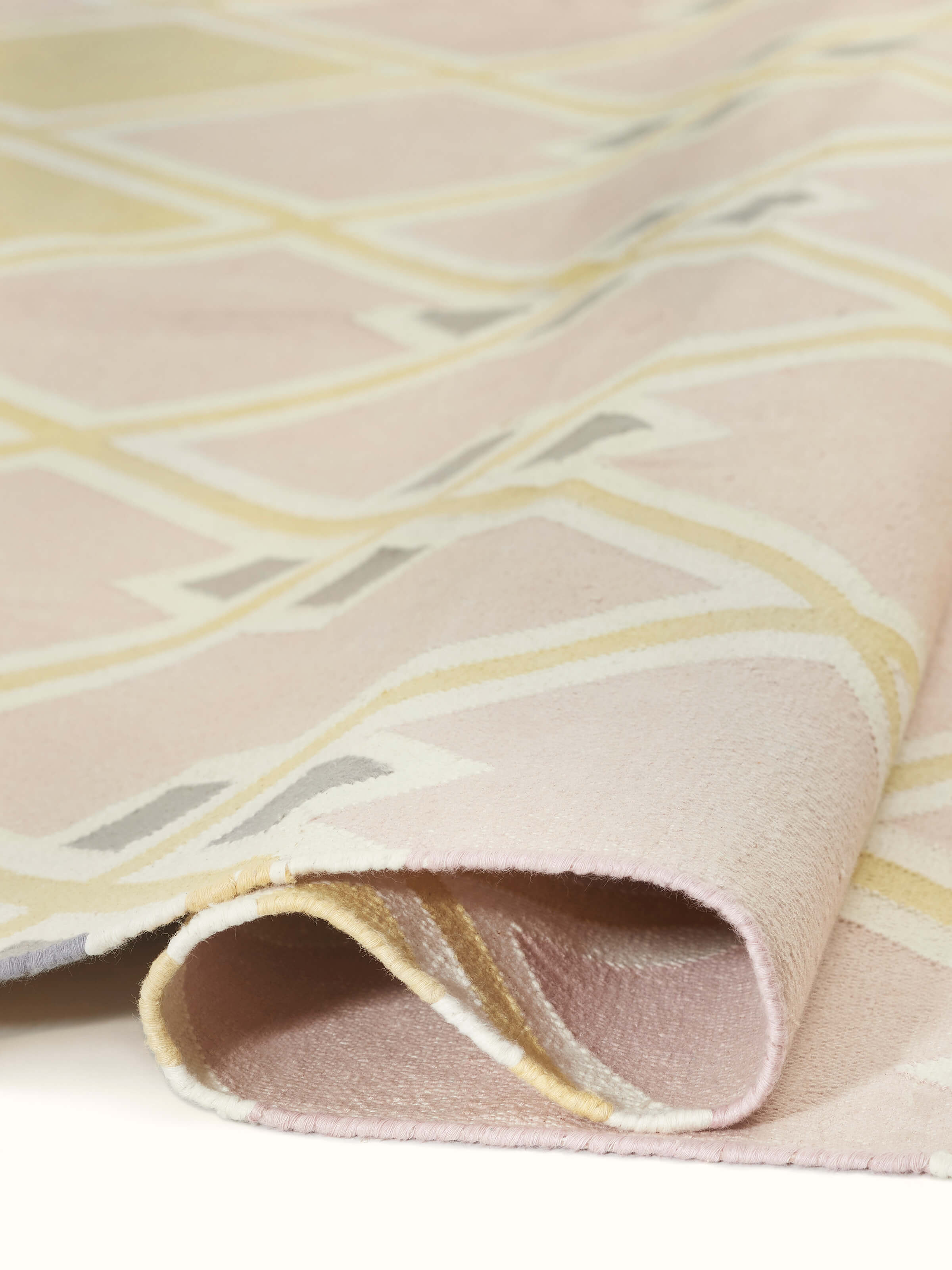 Modern geo light pink lawan cotton panja dhurrie shown in a setting, emphasizing its design and texture.