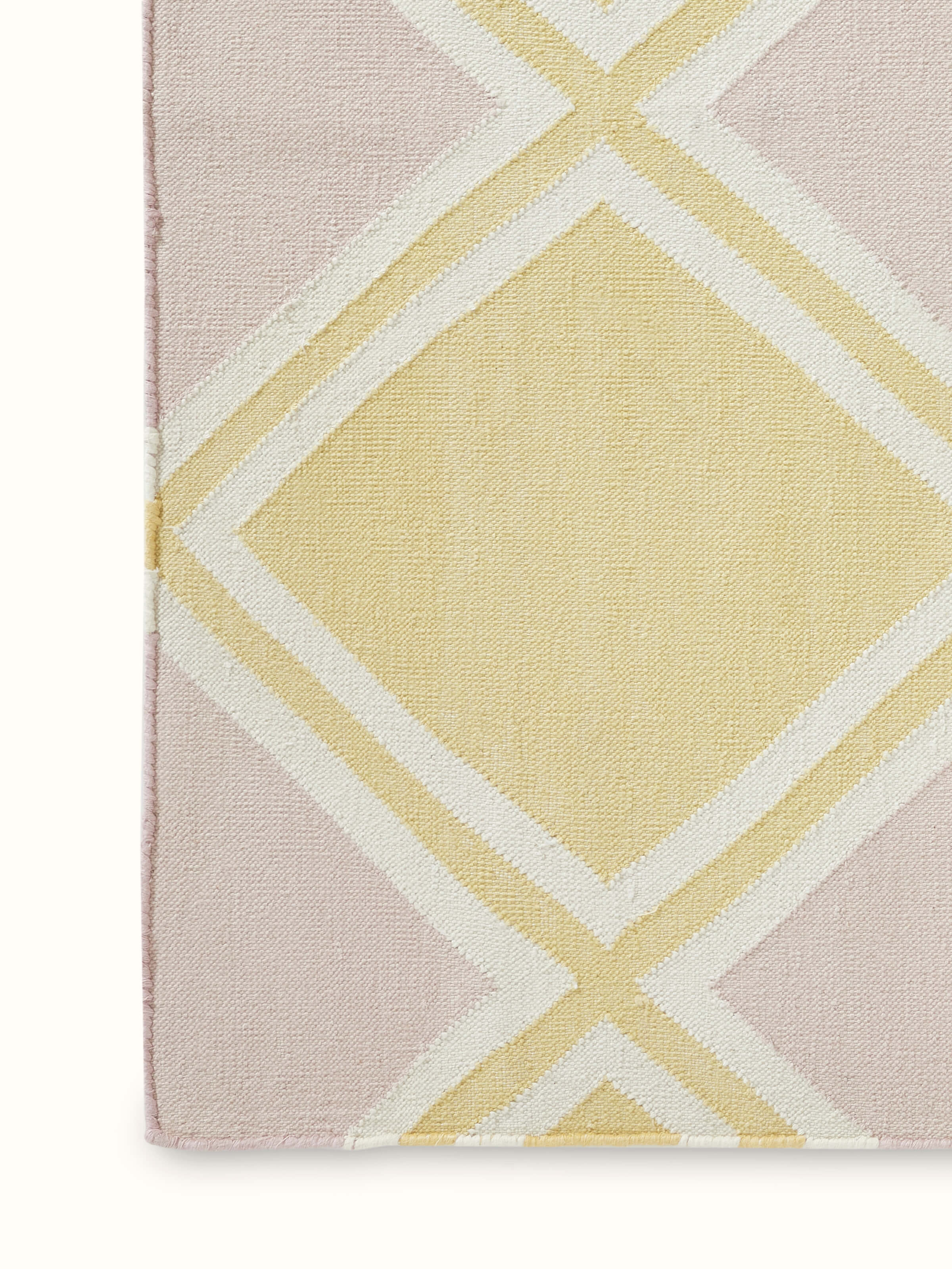 Close-up of Modern geo light pink lawan cotton panja dhurrie focusing on the soft cotton material and geometric pattern.