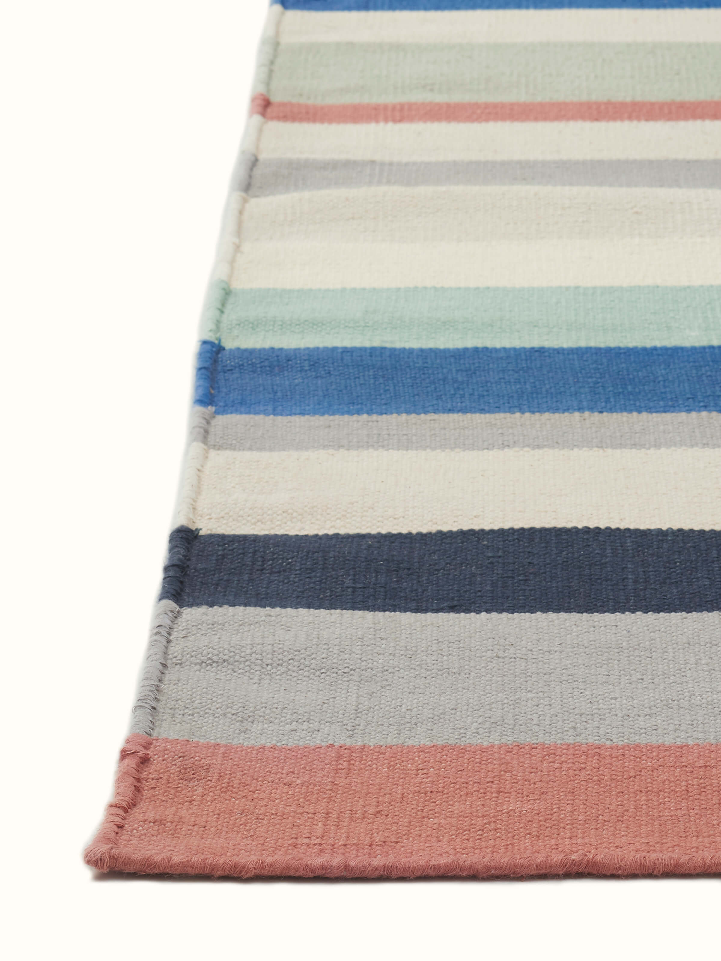 Angle view of Modern Geo Stripe Lawan Cotton Panja Dhurrie, highlighting the dhurrie's construction and color pattern.
