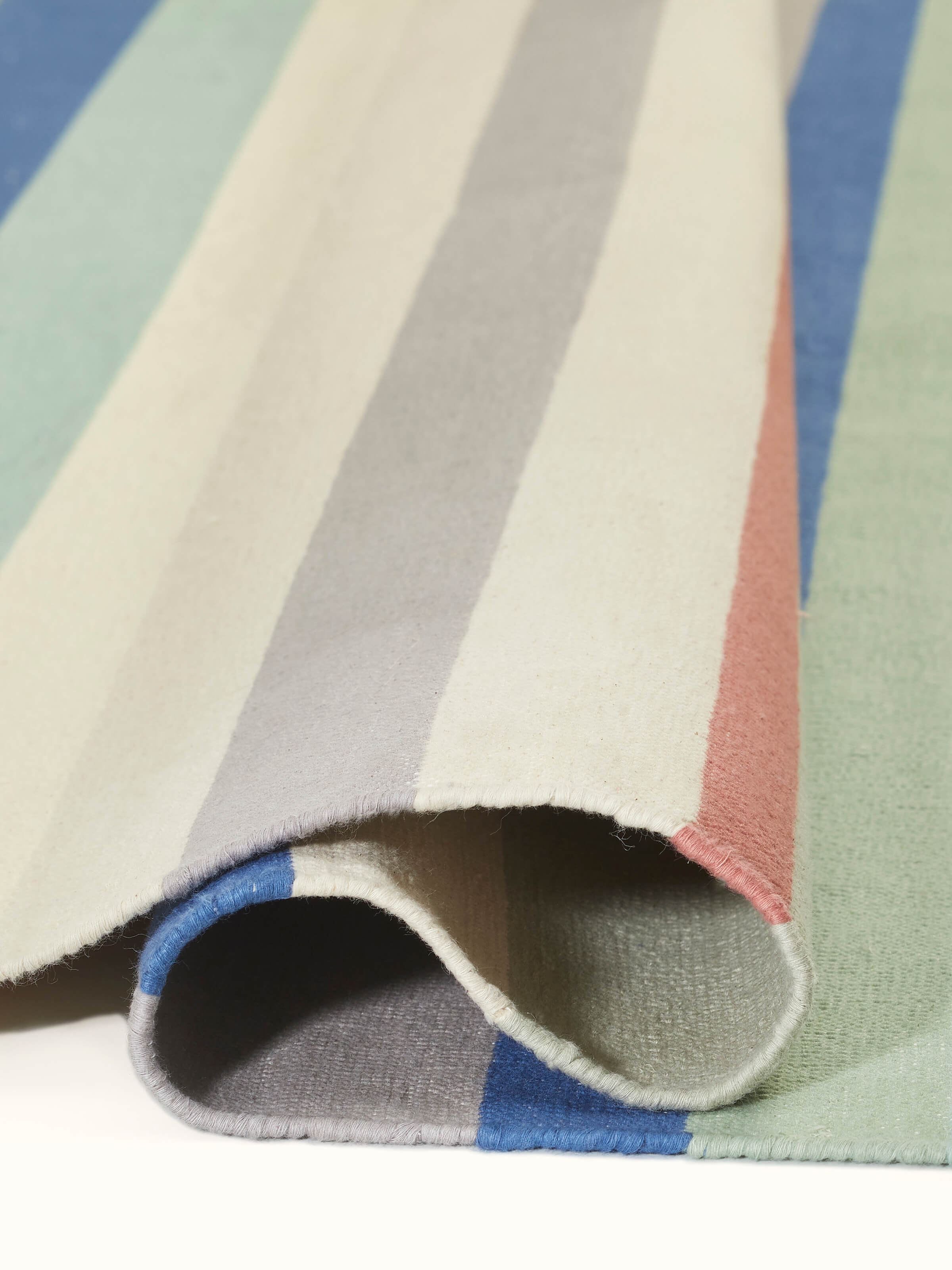 Side view of Modern Geo Stripe Lawan Cotton Panja Dhurrie, emphasizing its thickness and texture.