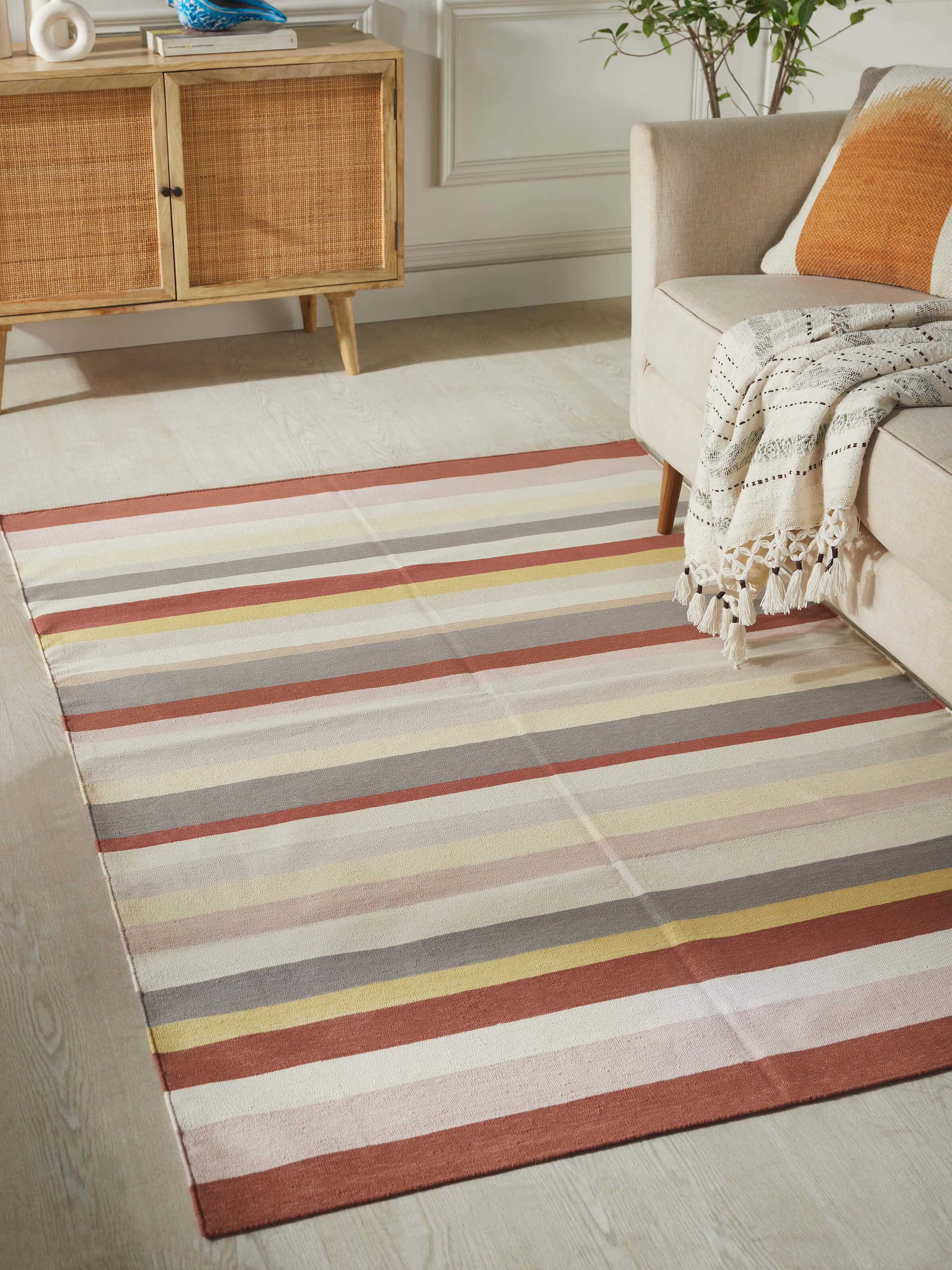 Close-up of Modern geo stripe rust lawan cotton panja dhurrie highlighting the detailed stripe pattern and texture.