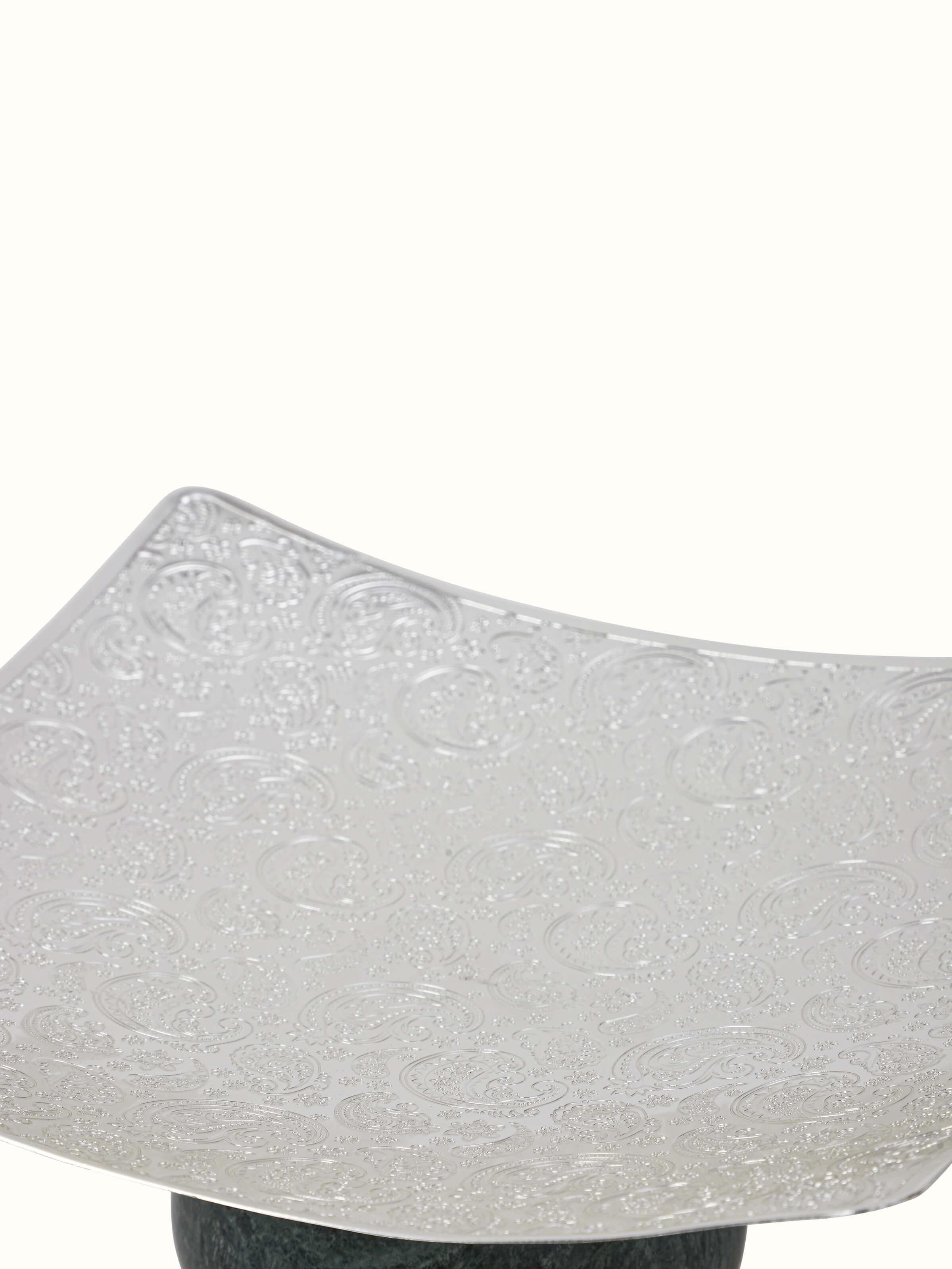 Detailed view of silver-plated paisley square platter with focus on pattern and shine.