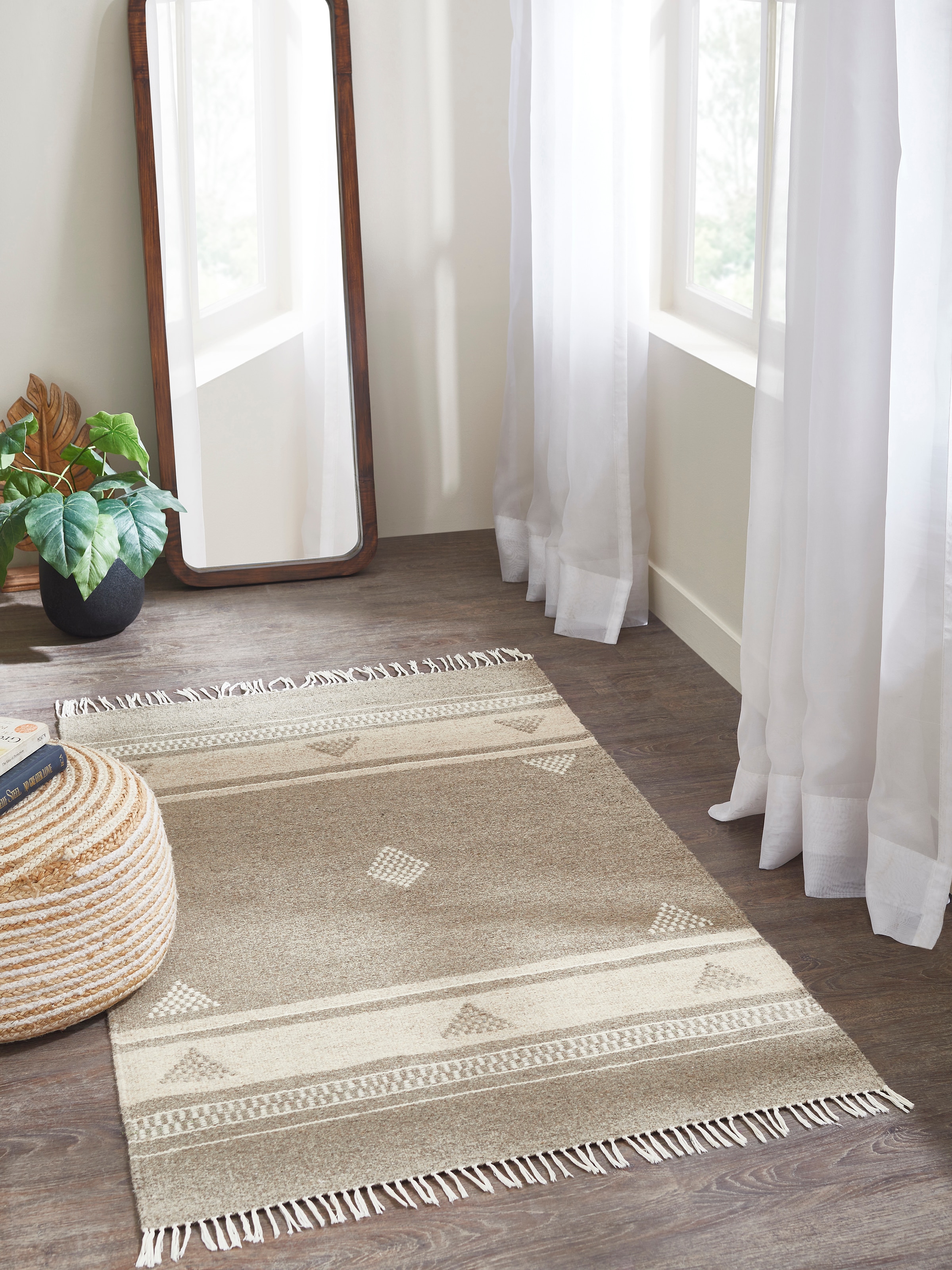 Lifestyle room view featuring beige Jawaja dhurrie with nomadic stripes and buti motifs.