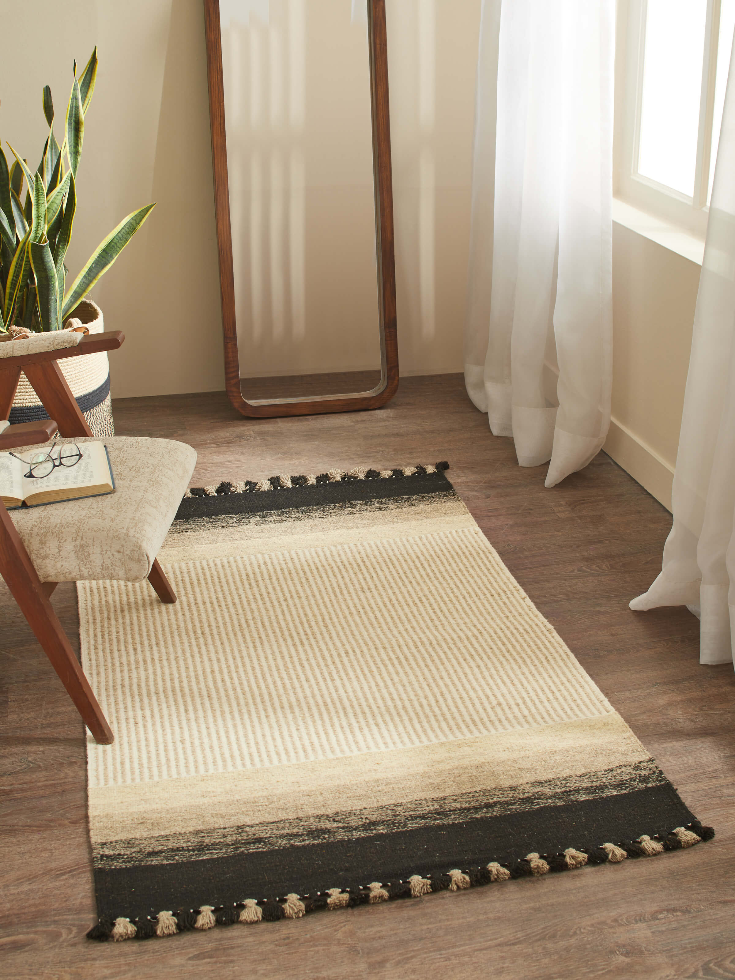 Overhead view of Jawaja Handloom Dhurrie in Beige and Black, showcasing bold textured stripes and handcrafted wool weaving in a 4x6 ft size.