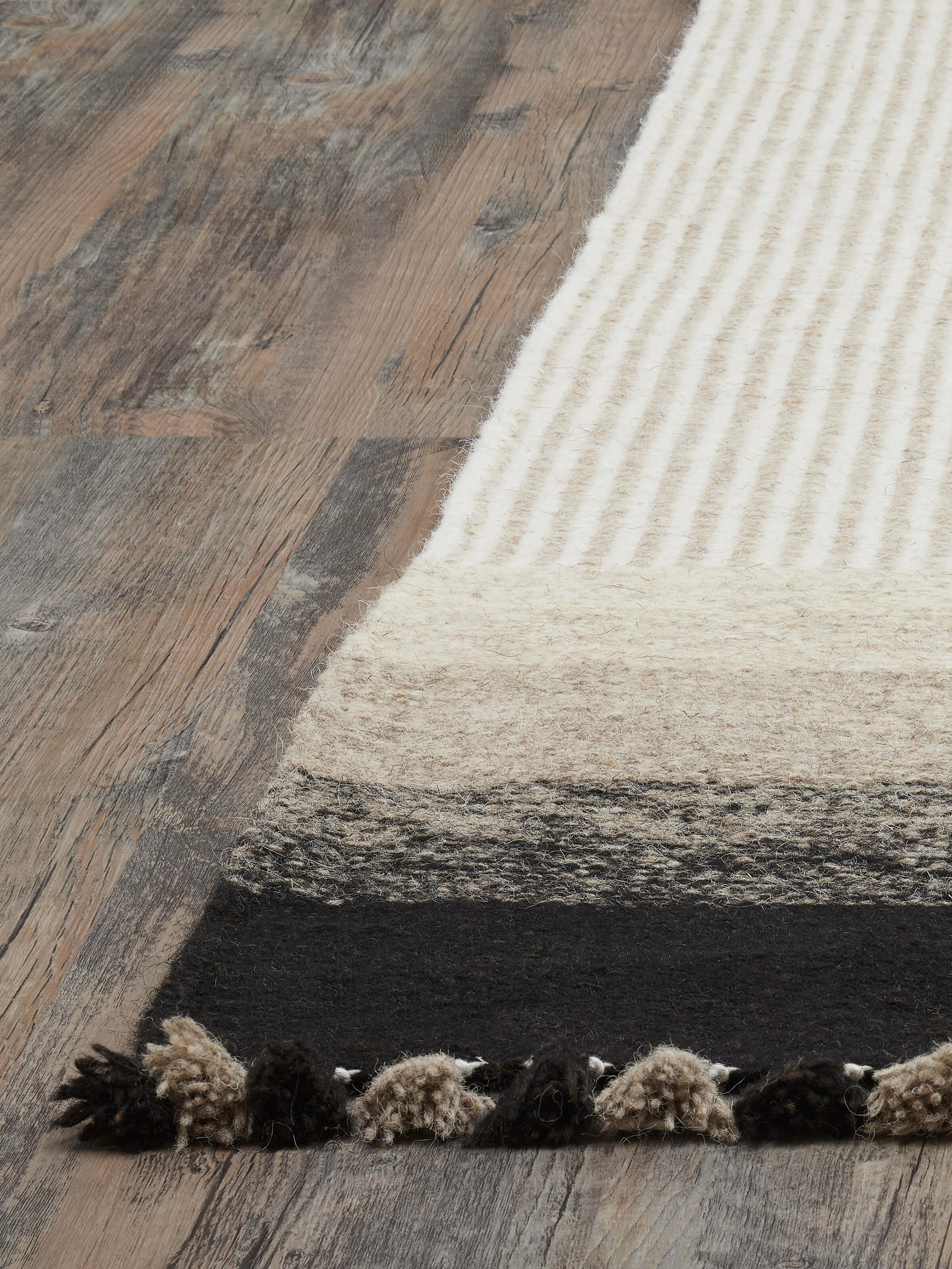 Angled view of Textured stripes beige black Jawaja wool & cotton handloom dhurrie (4x6 ft) showing design elements