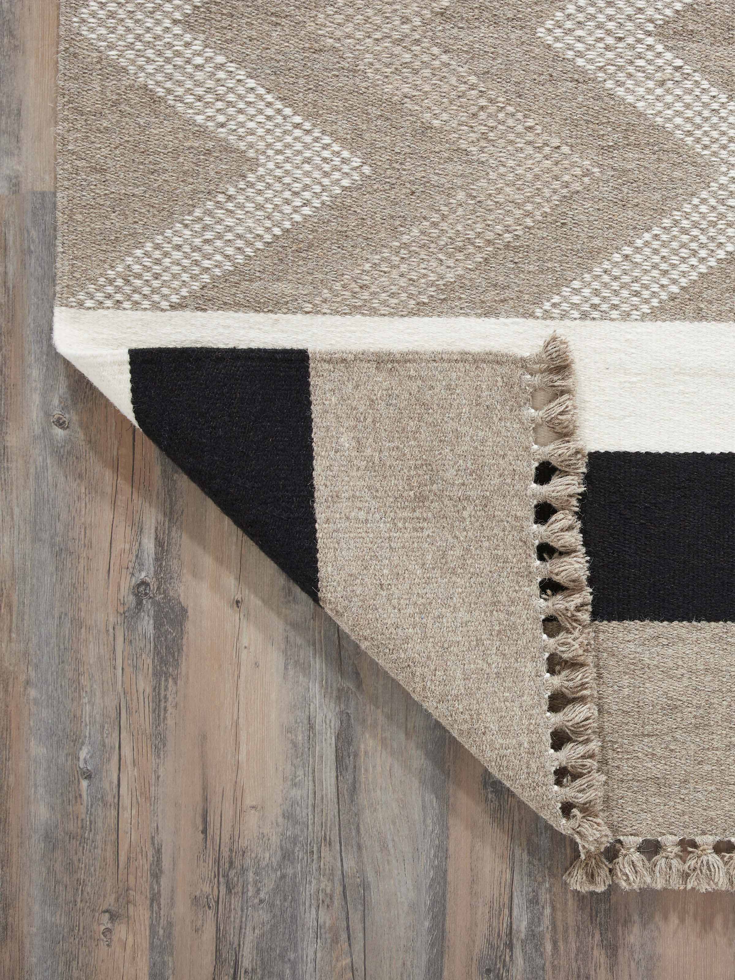 Side view of Textured Chevron Grey Melange Jawaja Wool & Cotton Handloom Dhurrie (3x5 ft), highlighting the thickness and quality of the weave.