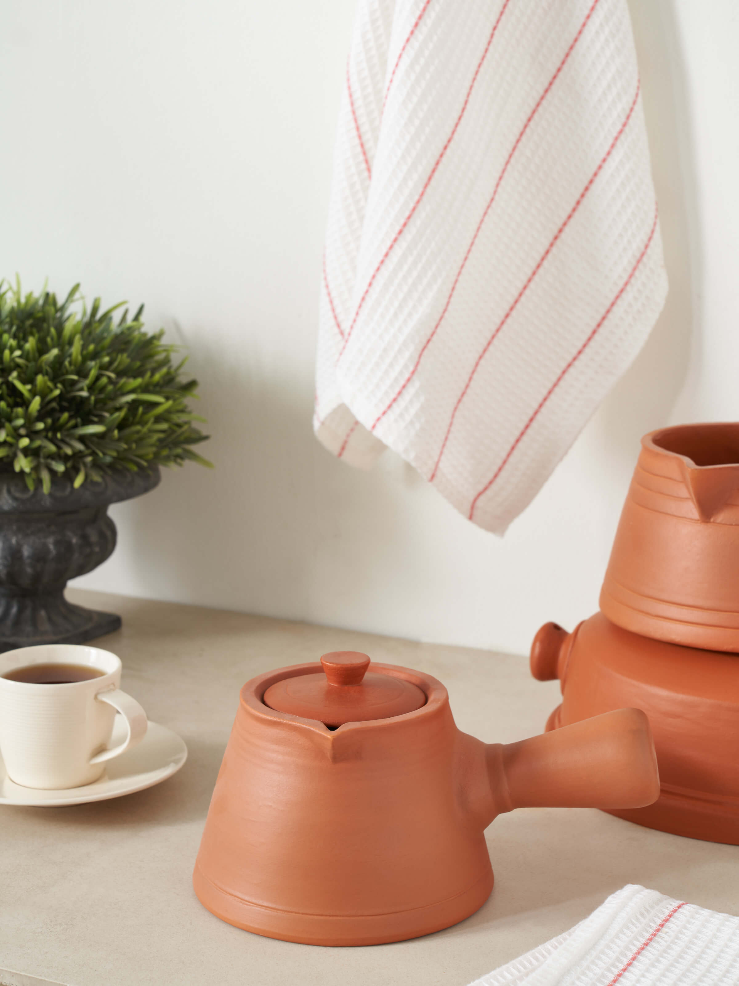 Front view of terracotta clay saucepan, highlighting its traditional shape and handcrafted details.