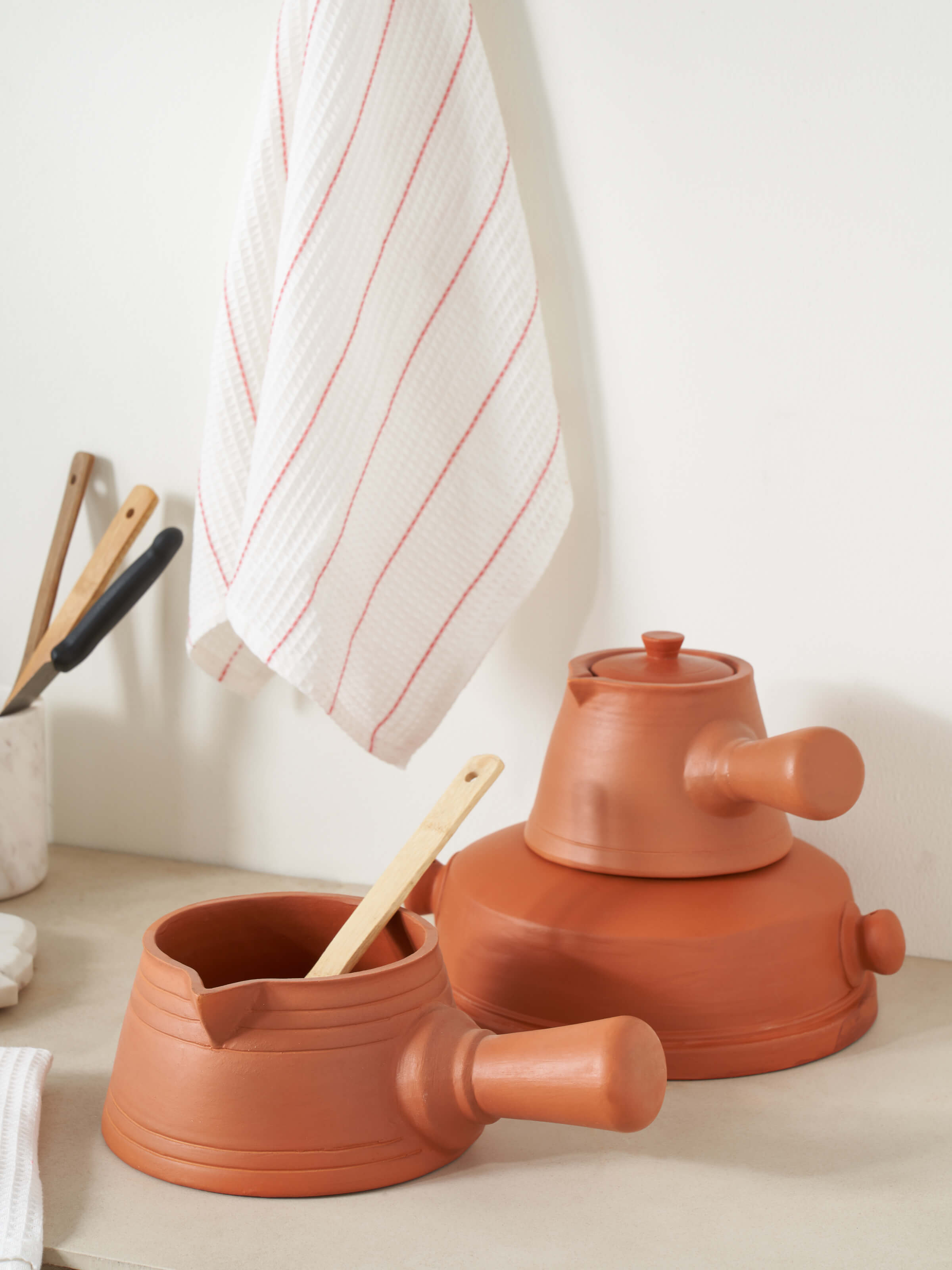 Side view of terracotta clay saucepan, emphasizing its sturdy design and artisanal craftsmanship.