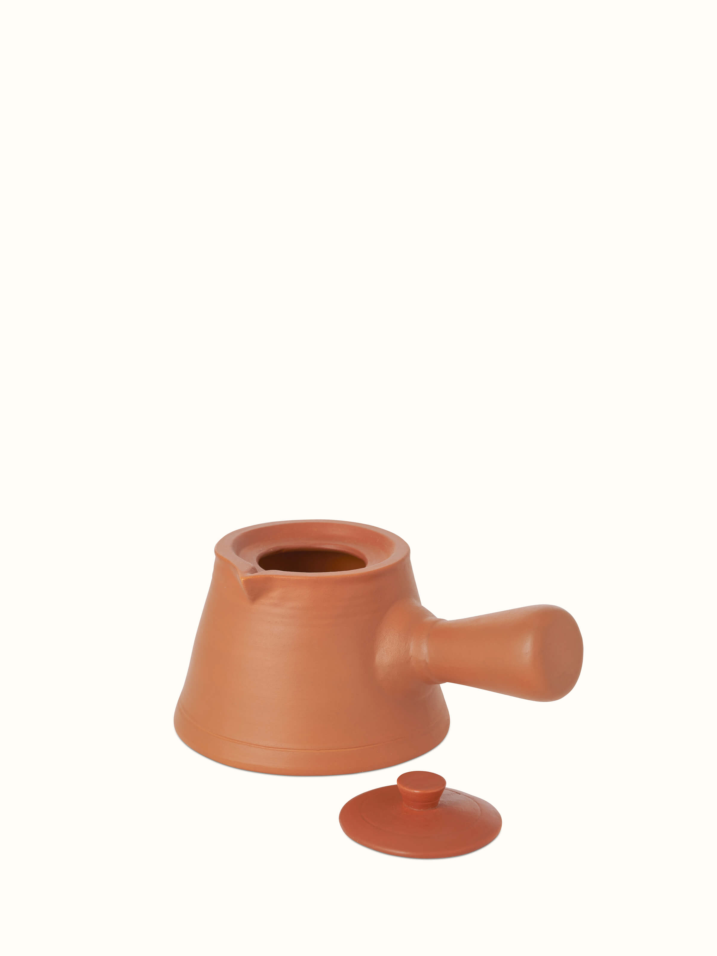 Angled view of terracotta clay saucepan, showcasing its functional design and rustic charm.