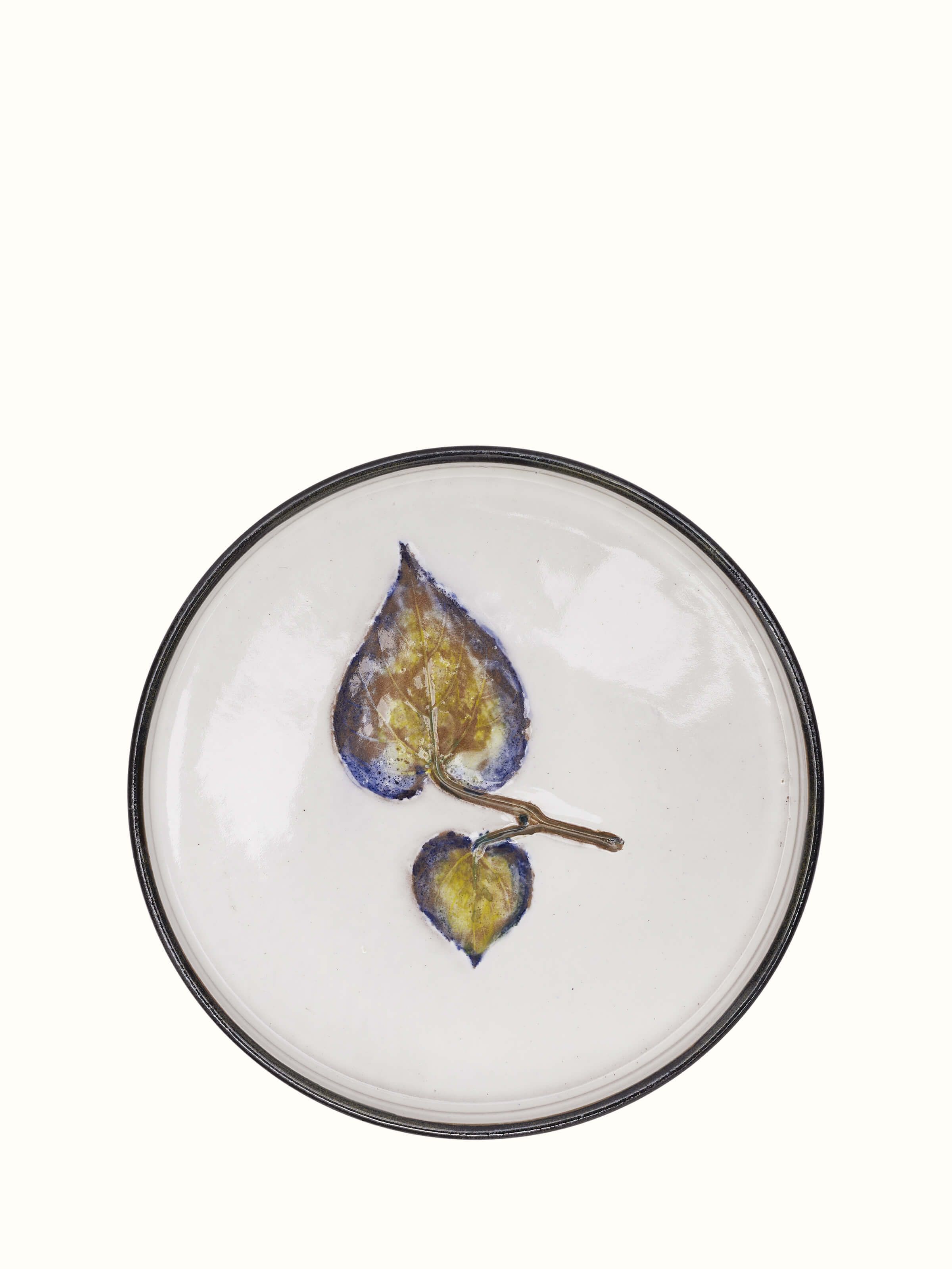 Close-up of studio pottery ceramic dessert plate highlighting its unique glaze and texture