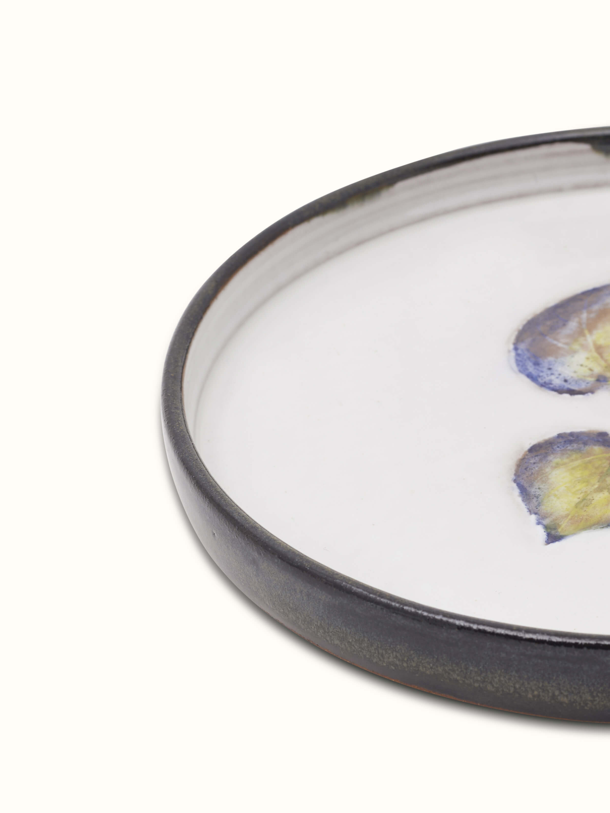 Detailed view of studio pottery ceramic dessert plate focusing on its artisanal craftsmanship