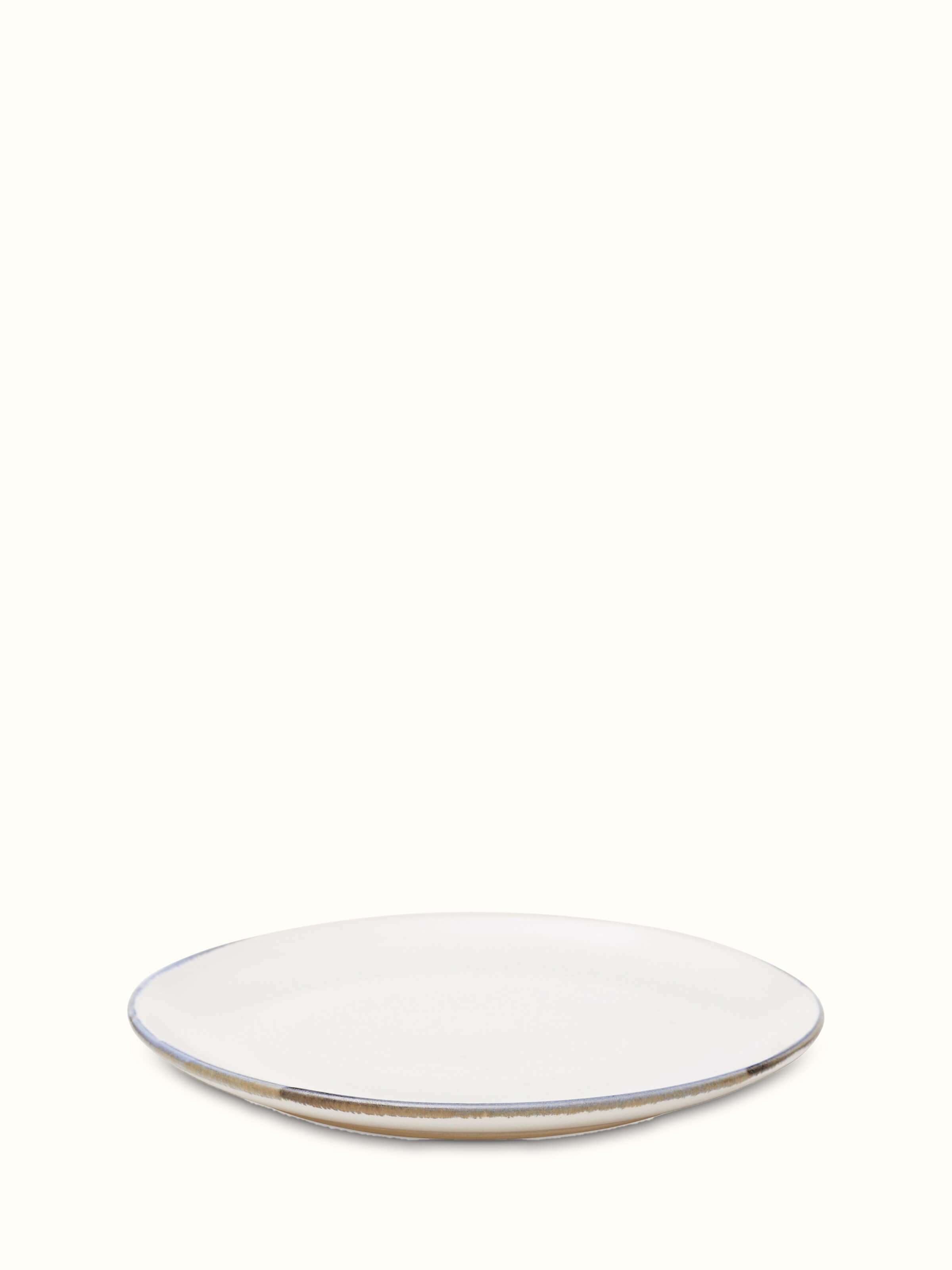 Angled view of studio pottery ceramic white dinner plate showcasing its clean lines and simple elegance