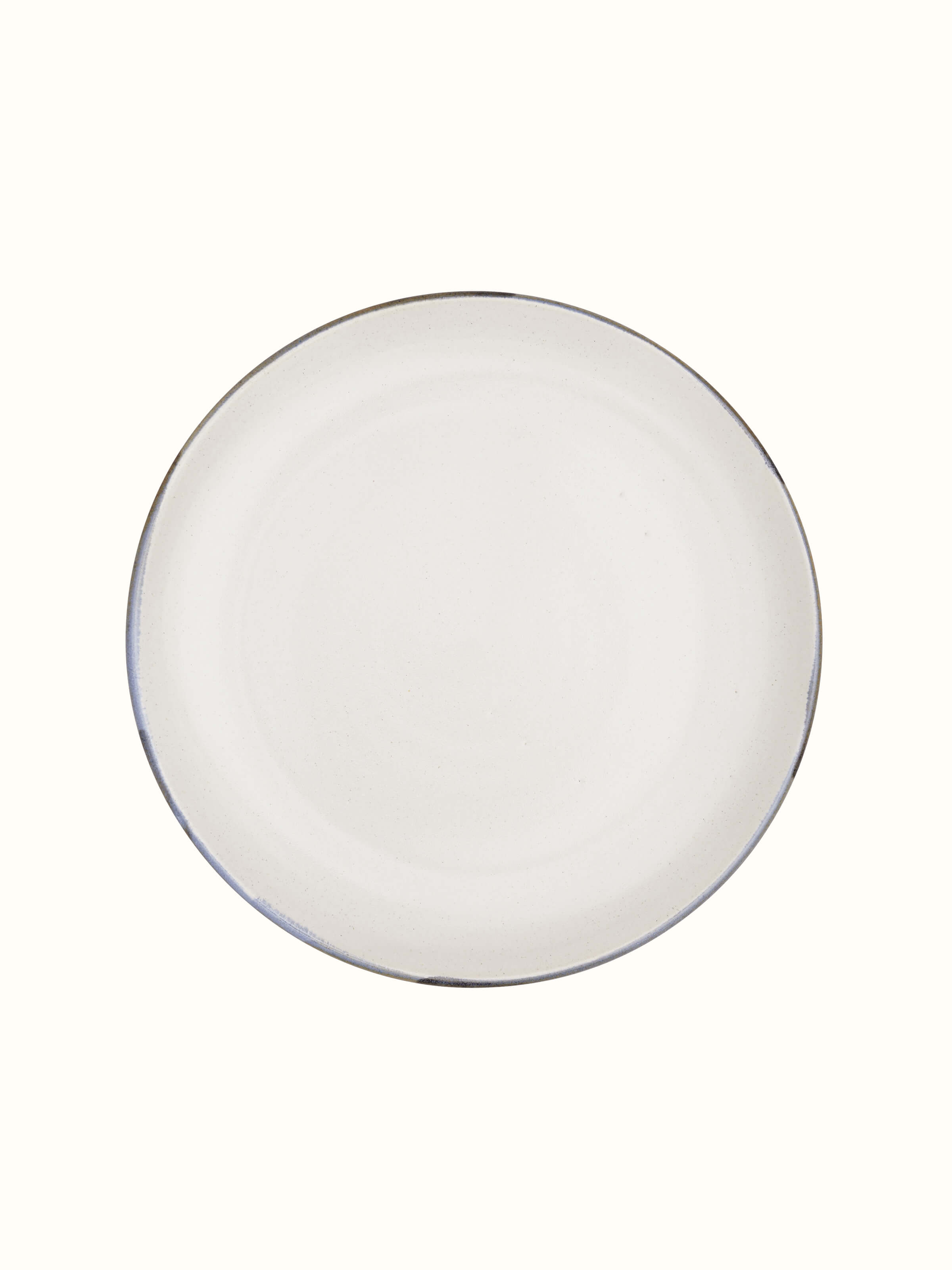 Side view of studio pottery ceramic white dinner plate emphasizing its subtle rim and smooth edge
