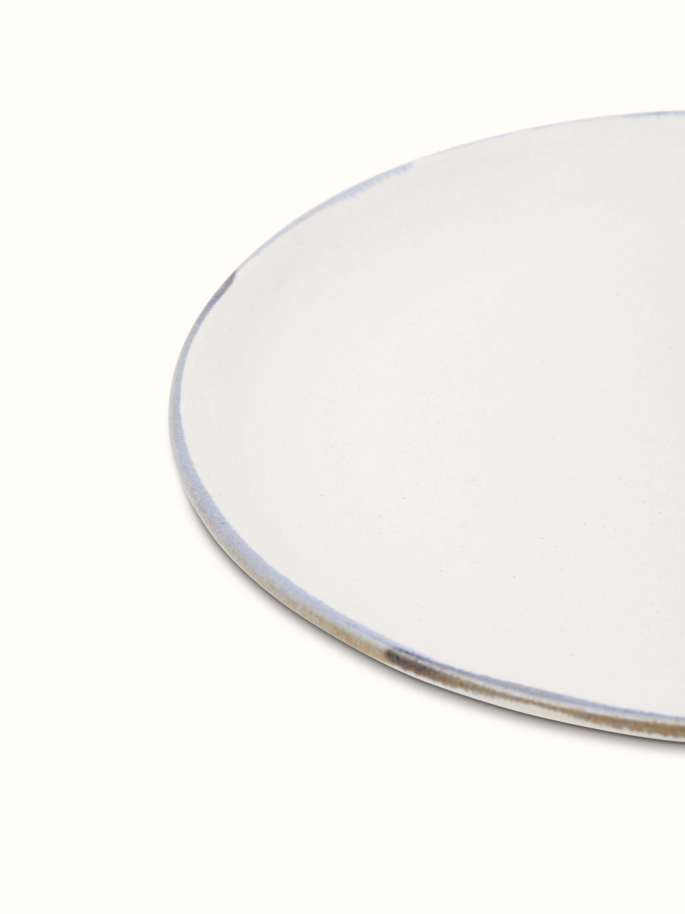 Close-up view of studio pottery ceramic white dinner plate displaying its high-quality glaze and understated design