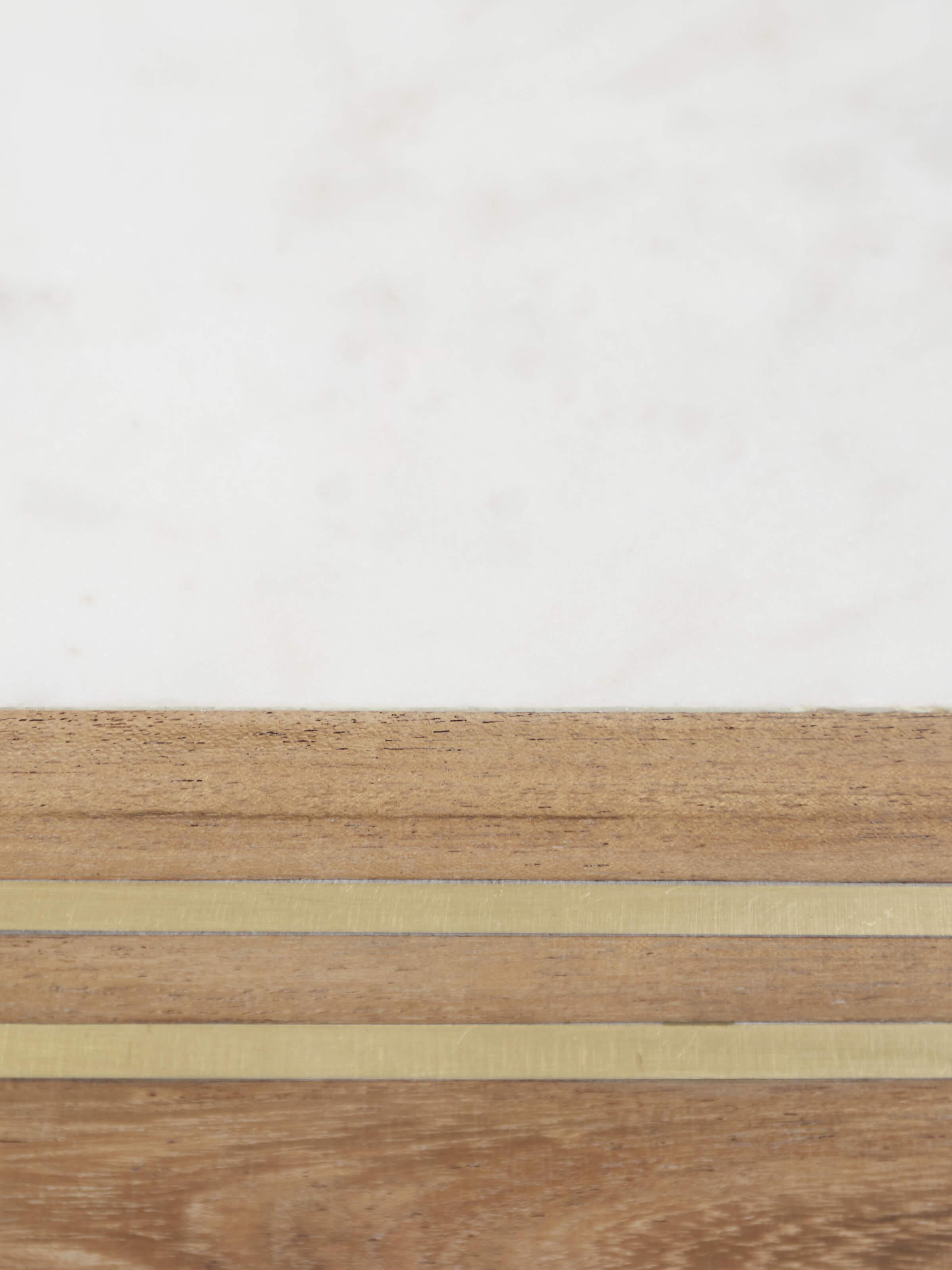 Close-up of marble inlaid cheese board with focus on the marble's smooth surface and design.