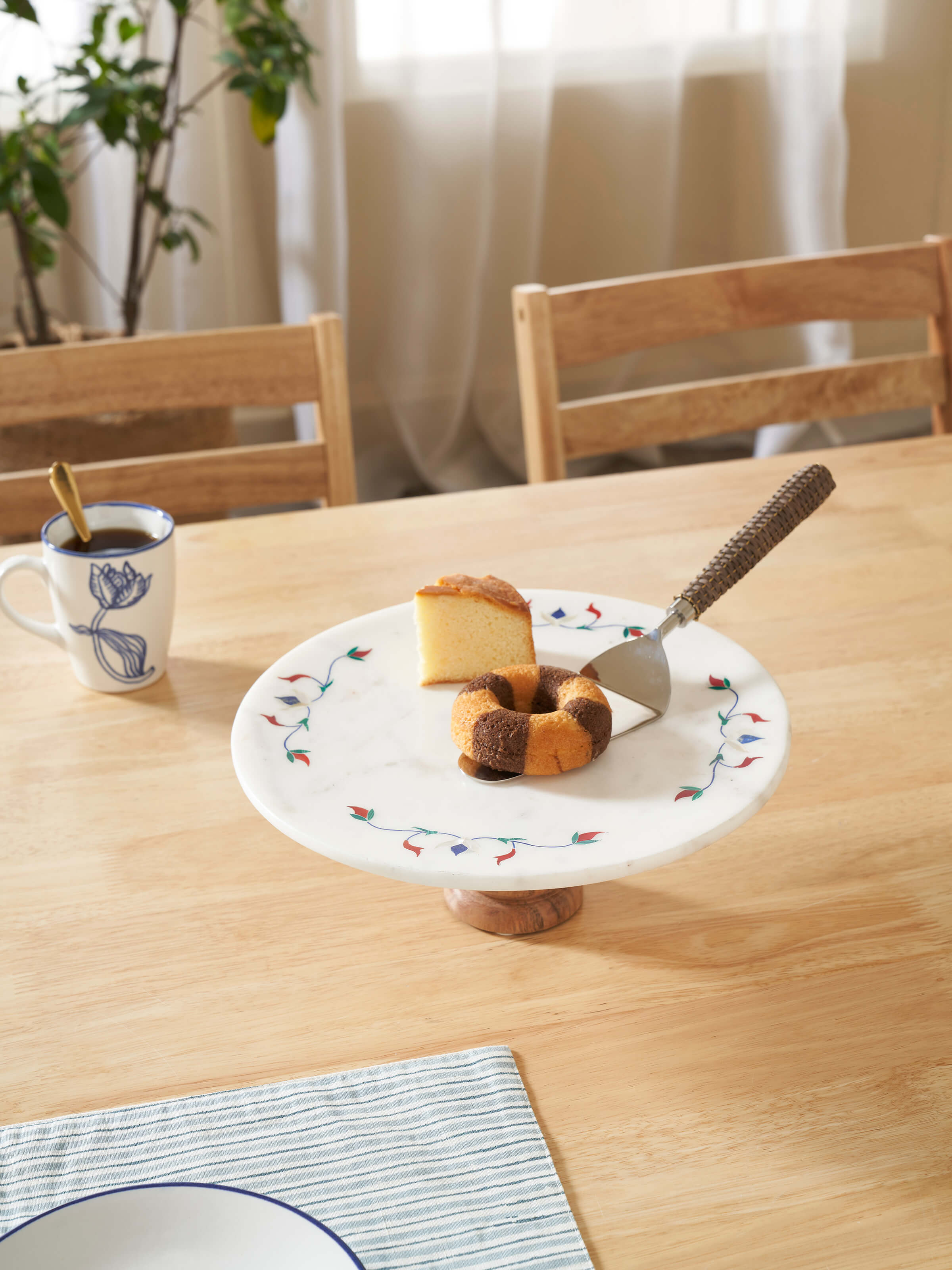 Close-up of marble inlaid circular cake stand, highlighting the detailed floral inlay and polished surface.