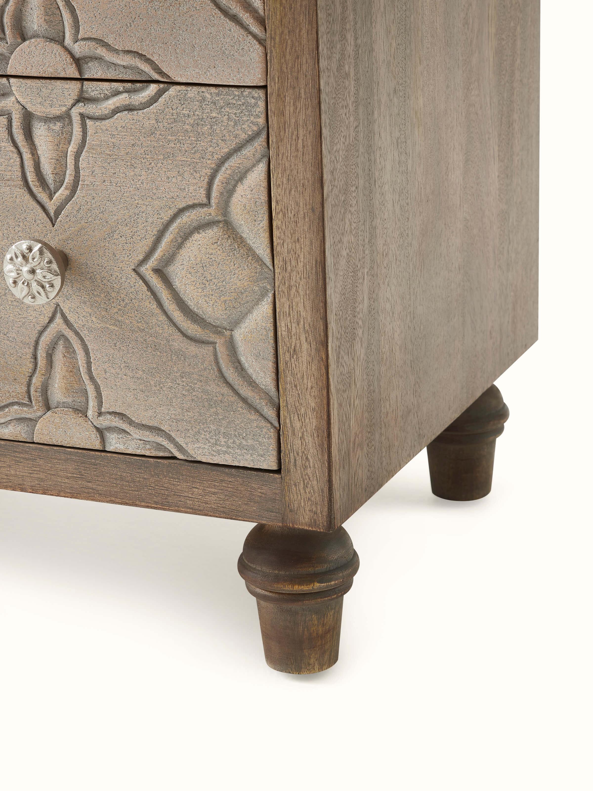 Detailed view of the mango wood chest of drawers, emphasizing the wood grain and carved designs