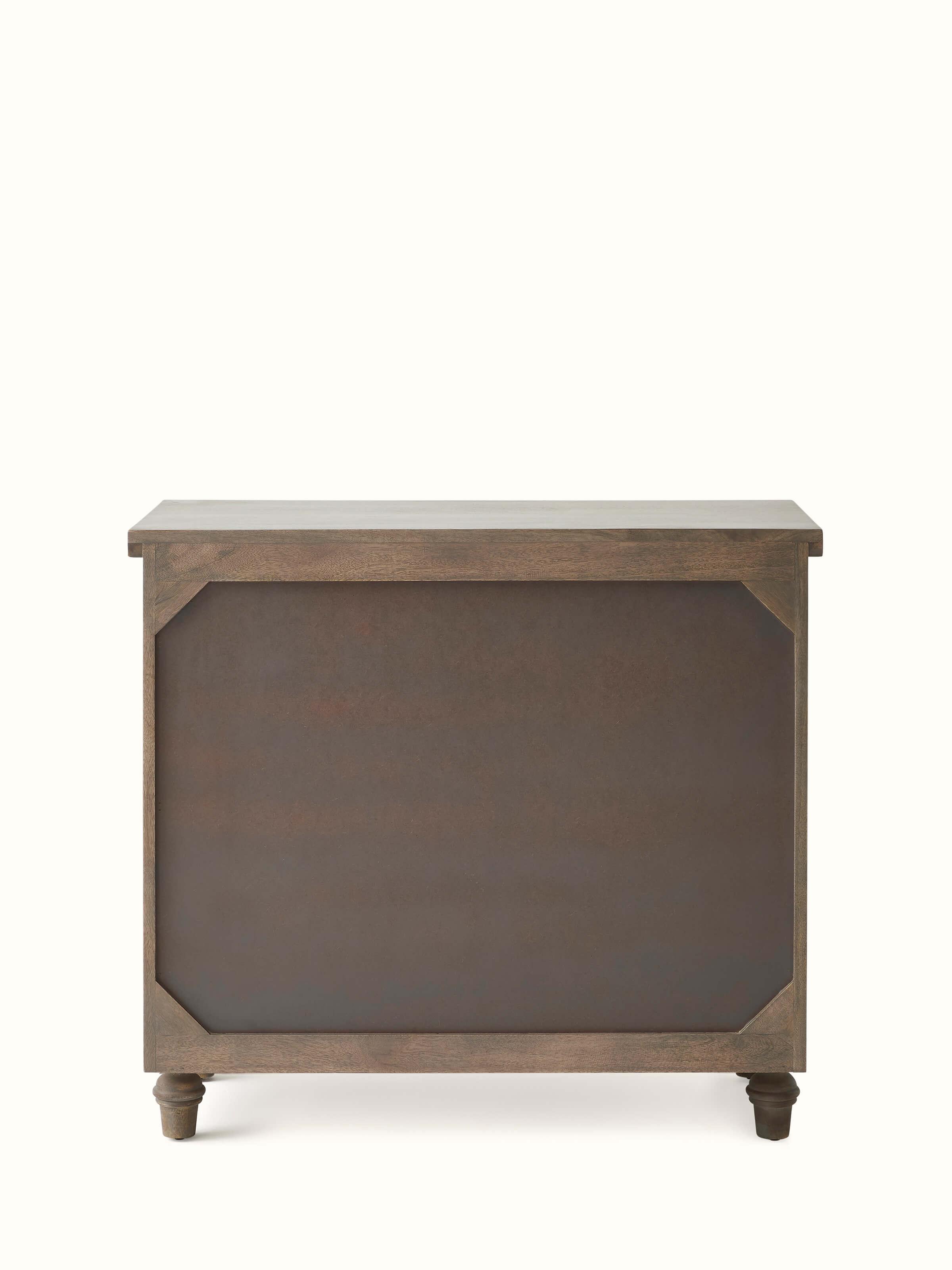 Angled view of the mango wood chest of drawers, displaying the overall design and carved patterns