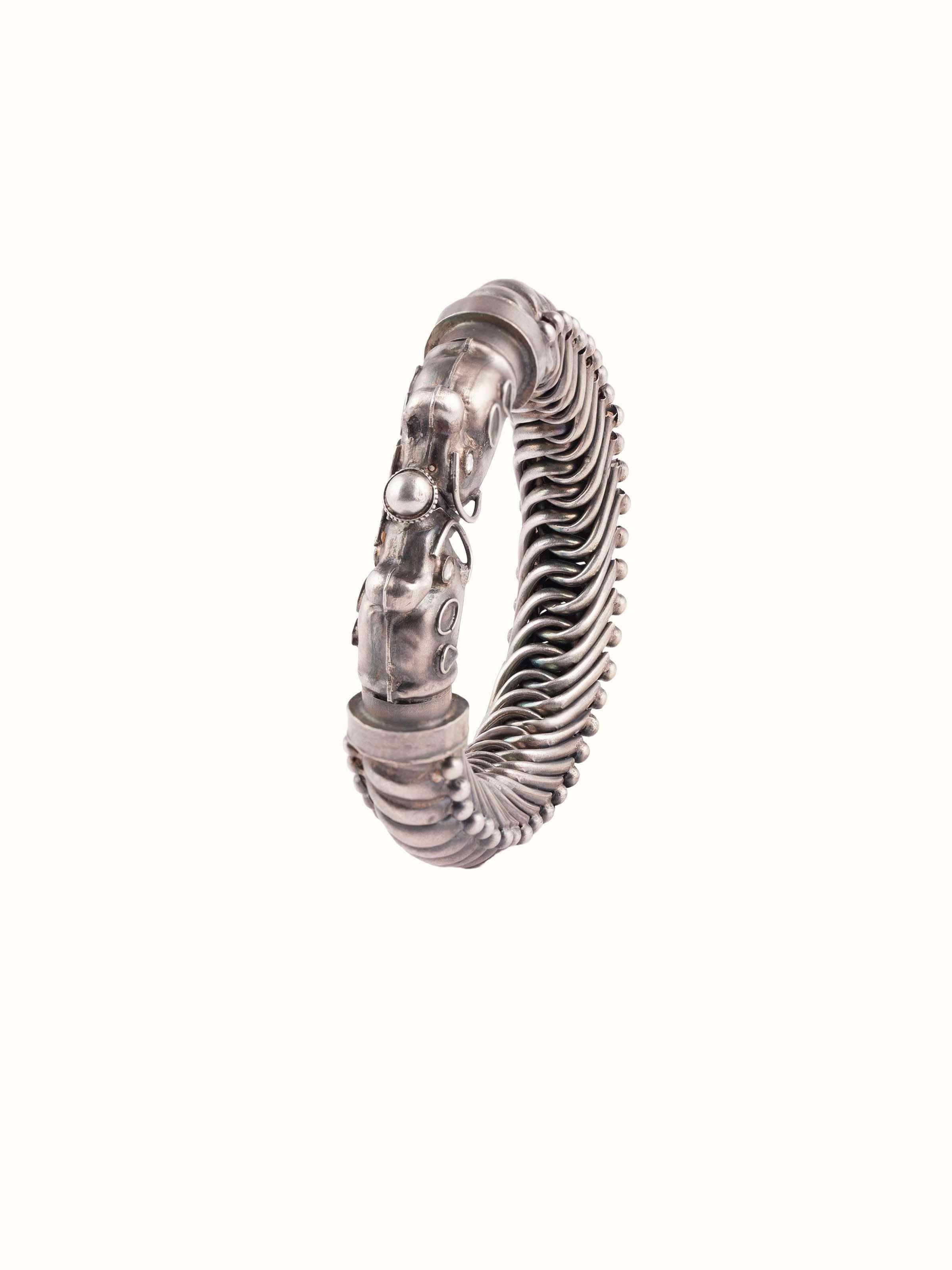 Front view of silver smithing bangle featuring detailed silverwork and a polished finish.