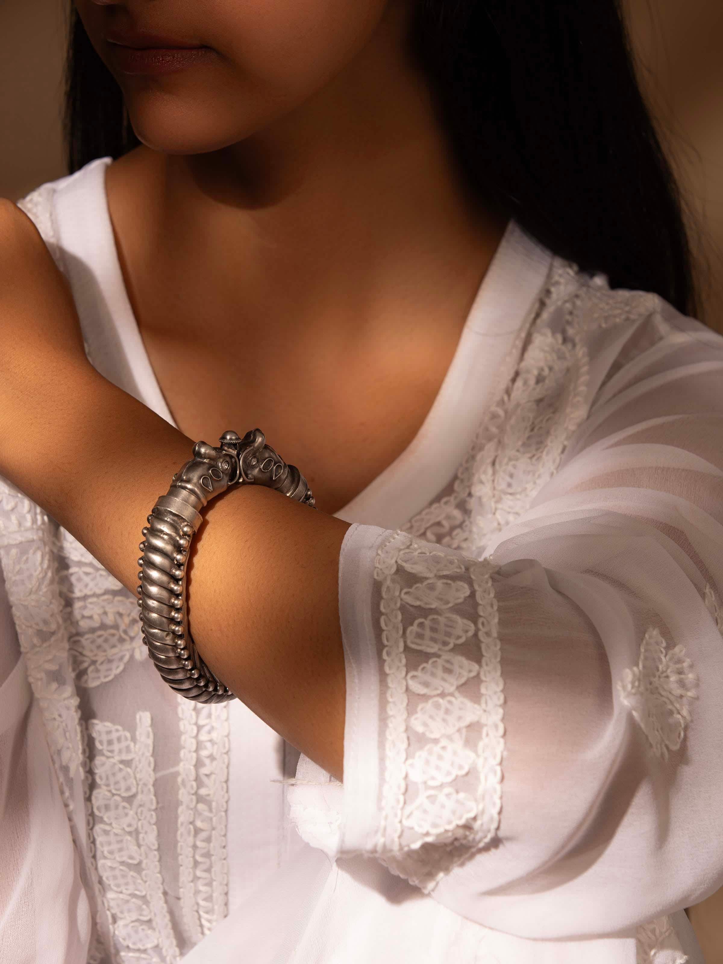 Close-up of silver smithing bangle showcasing detailed silver craftsmanship and shine.
