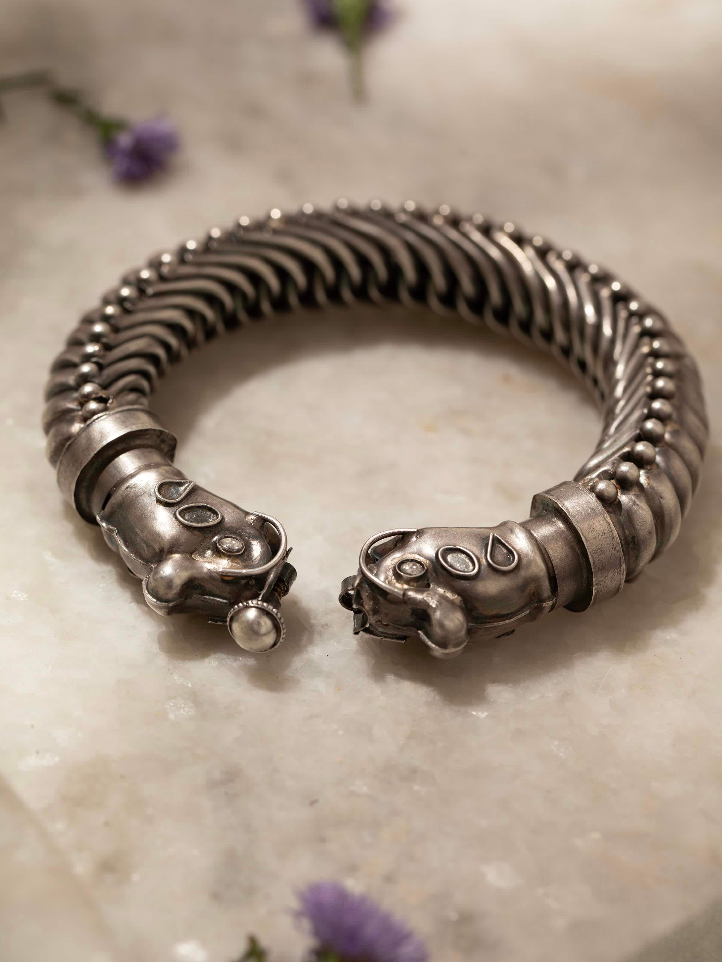 Detailed view of silver smithing bangle’s intricate detailing and polished surface.